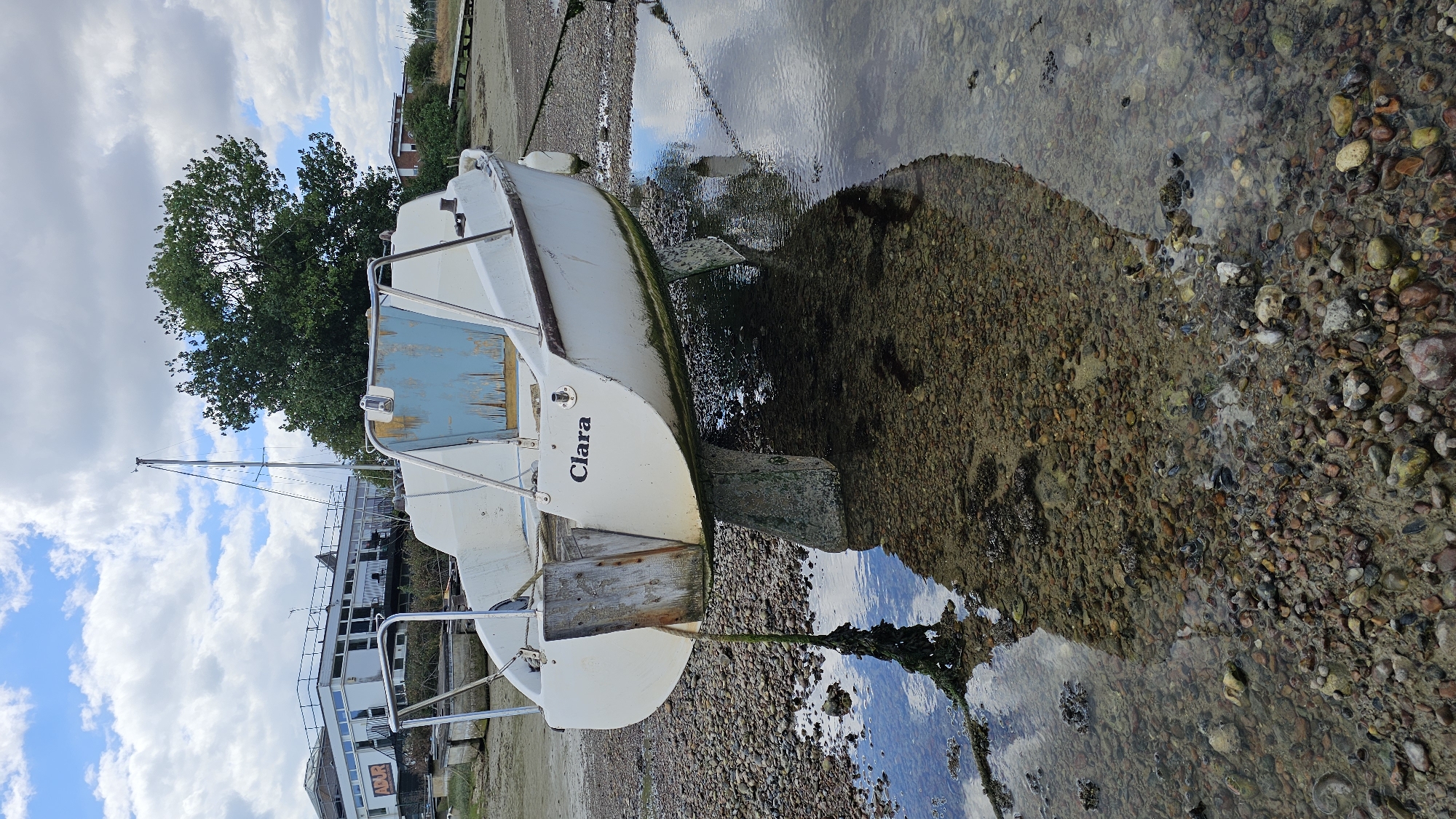 Low tide grounds boats on the Adur shore as a festival sets up nearby