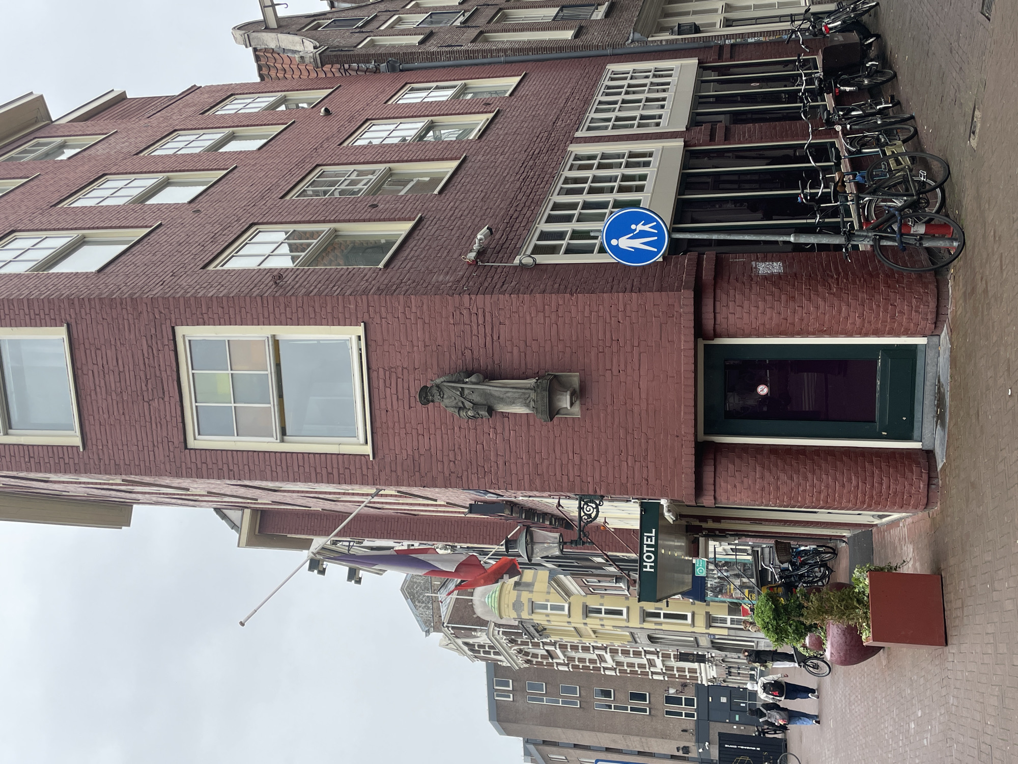 Tourist boat navigates Amsterdam canal amid historic brick buildings