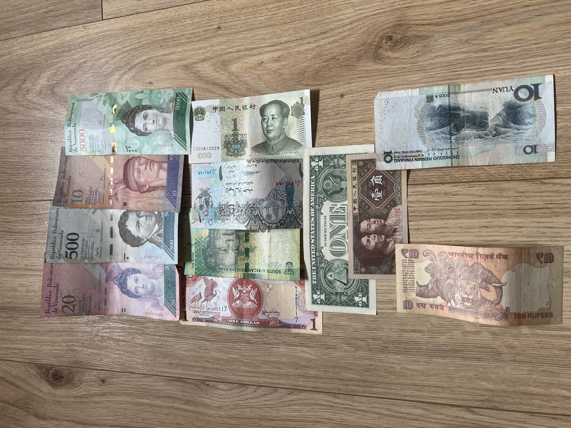 Foreign currency collection documented on wooden surface