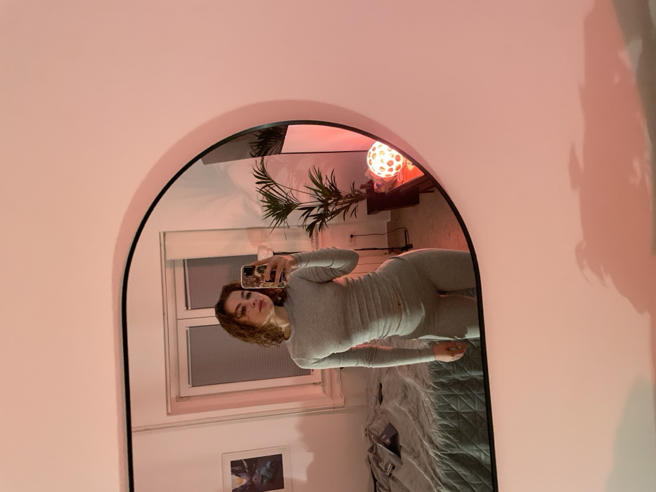 Woman takes mirror selfie in Belgrade bedroom
