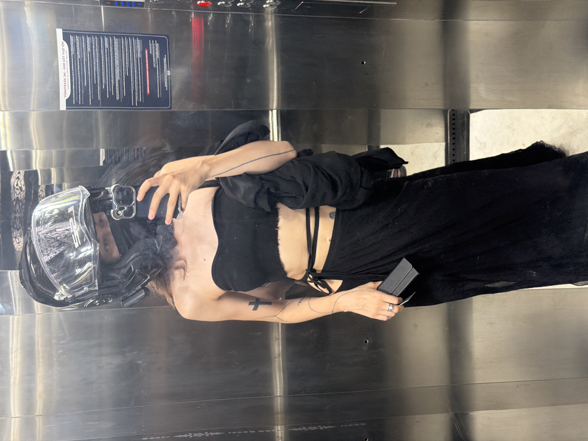 Helmeted person observed in elevator holding phone, Da Nang