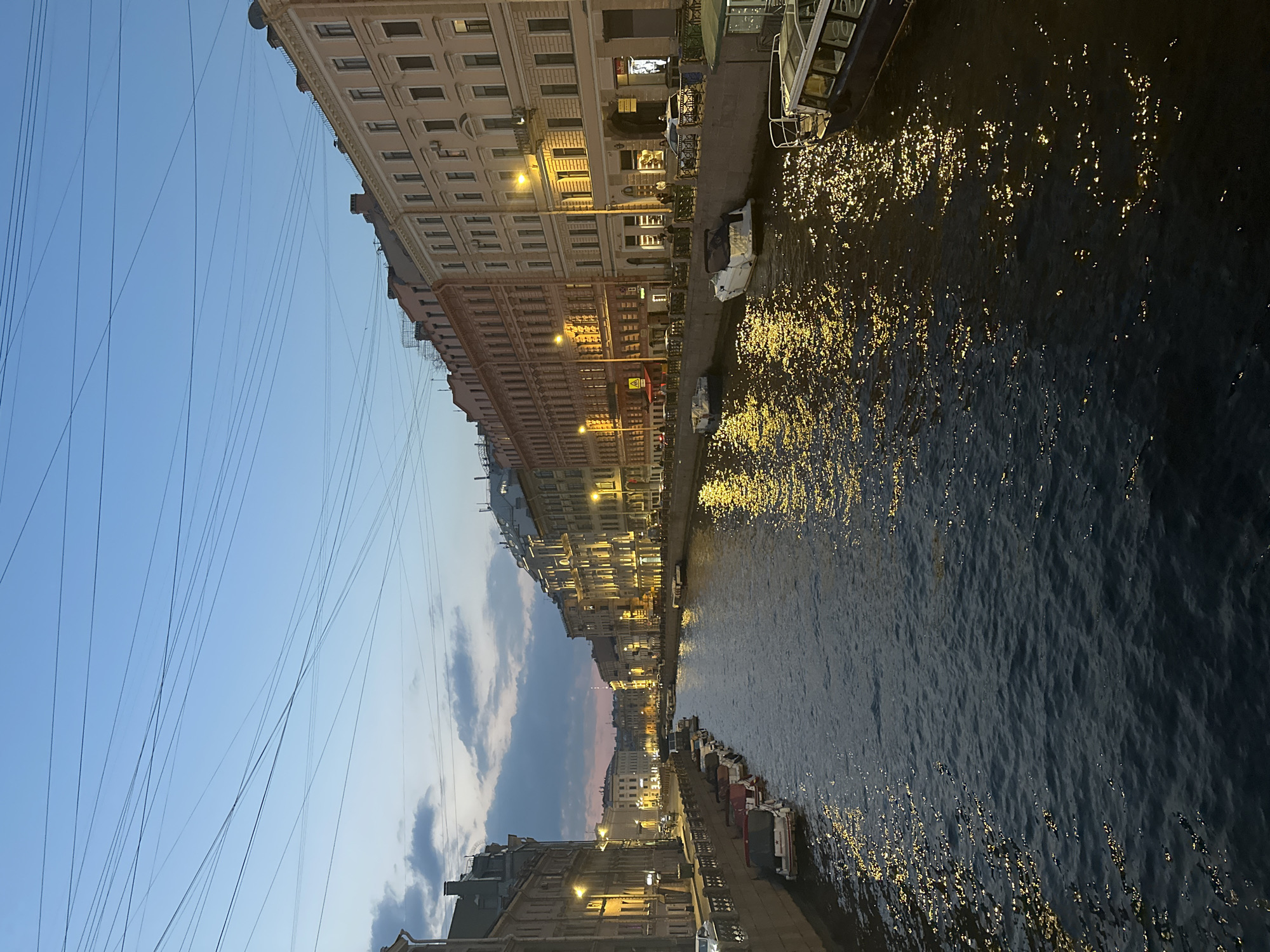 Urban canal scene documented at dusk, historical buildings illuminated