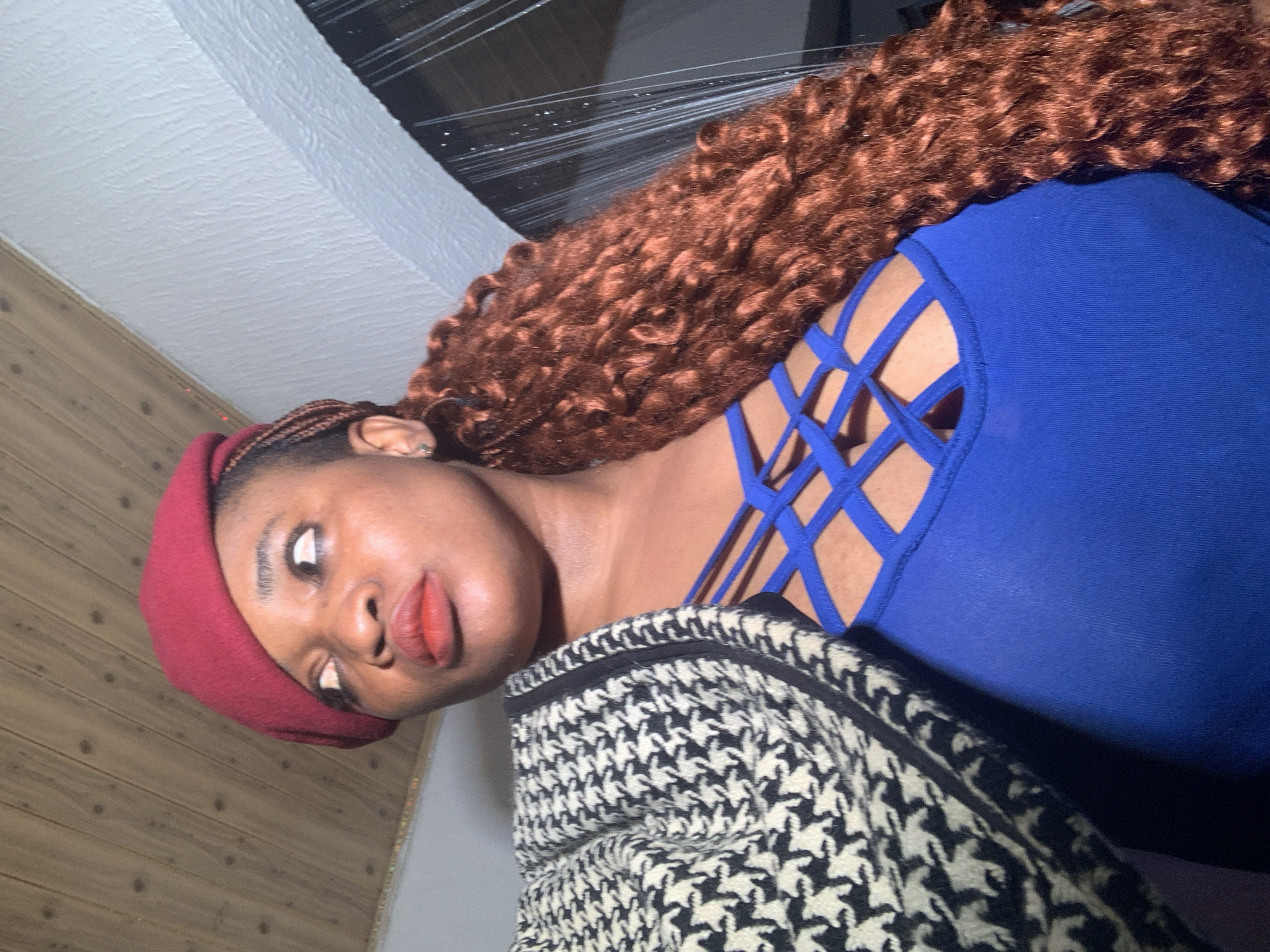 Woman takes indoor selfies in red beret, Nigeria