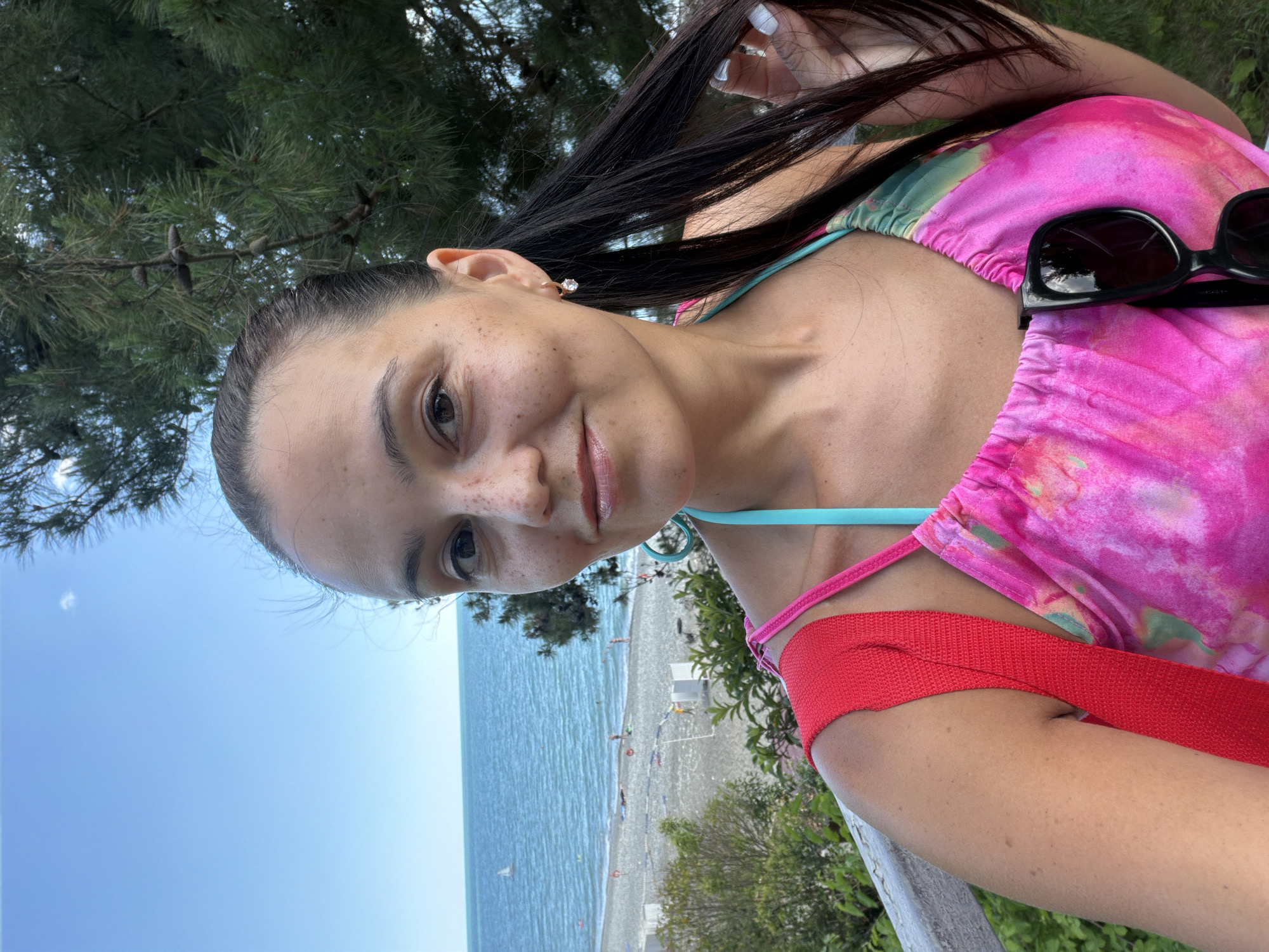 Outdoor portrait session, hair back, faint smile near the beach
