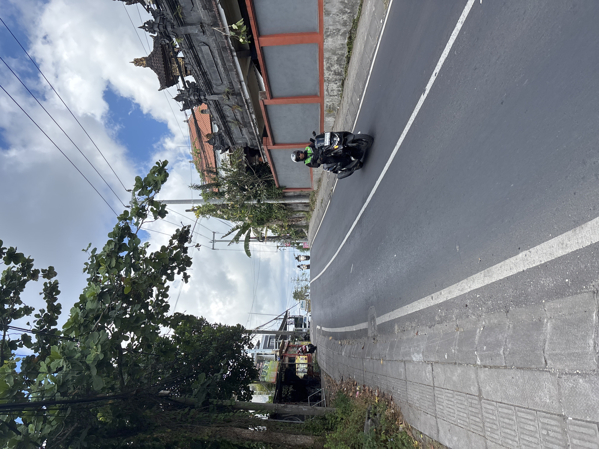 Tourist documents daytime street life in Kuta Selatan