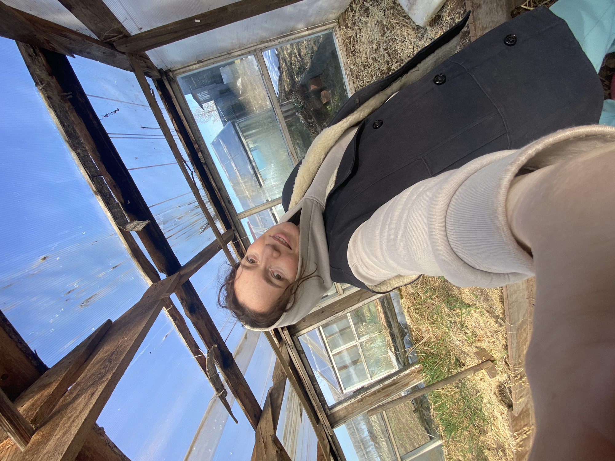 Woman photographs herself at abandoned greenhouse in rural Russia