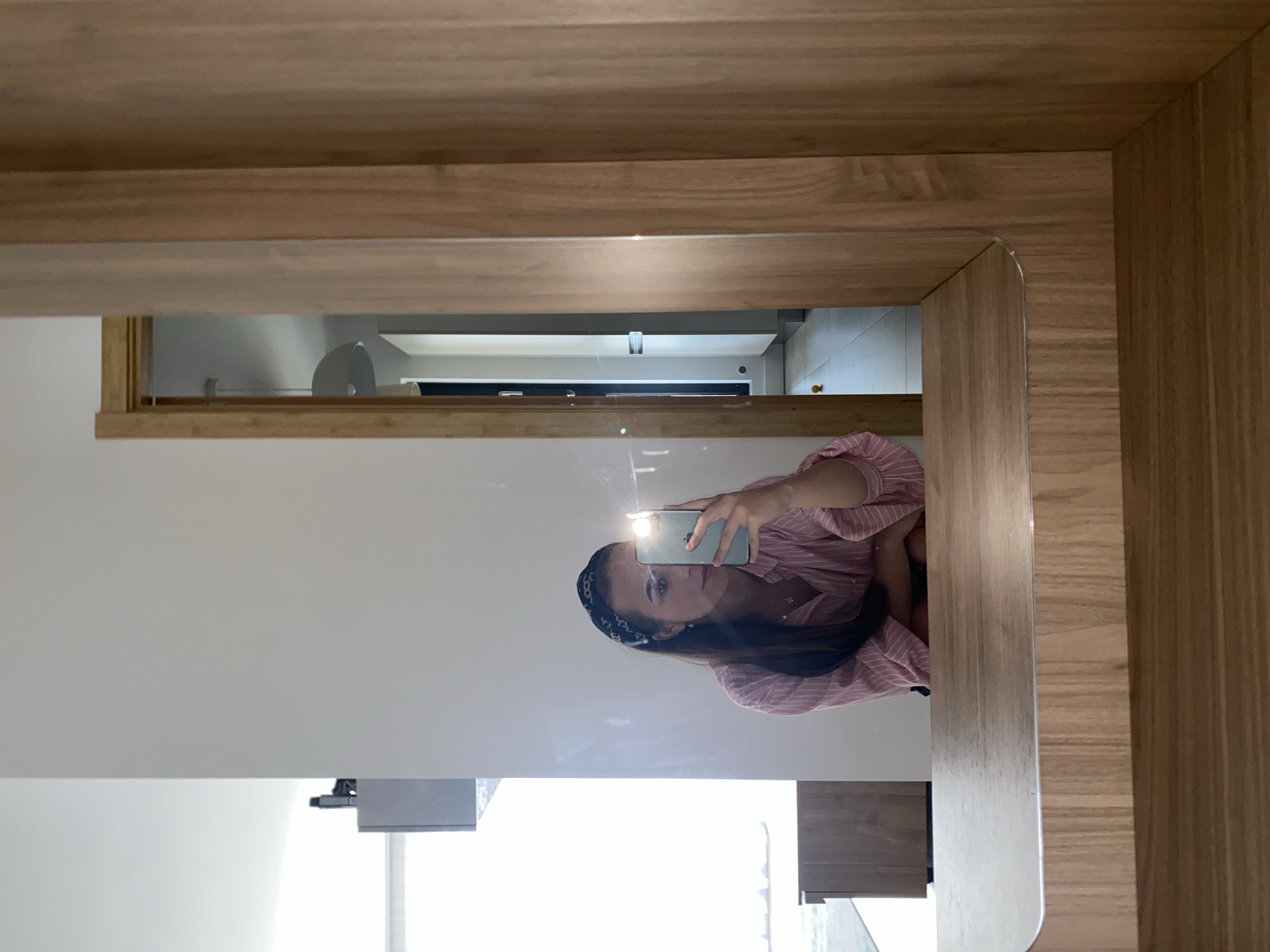 Mirror selfie session in a Bucharest apartment, pink striped shirt.