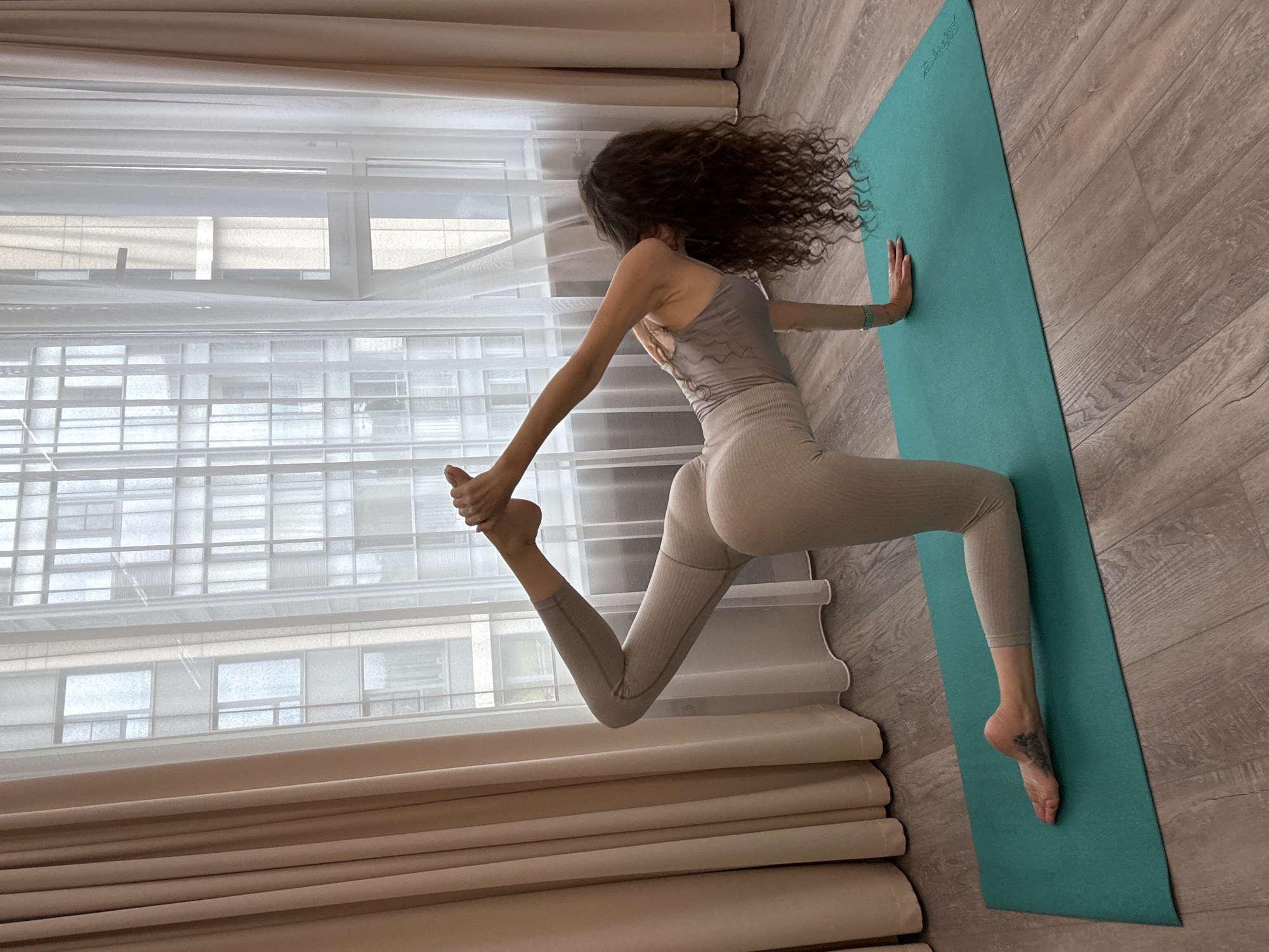 Morning yoga session in a Khimki apartment, city views outside