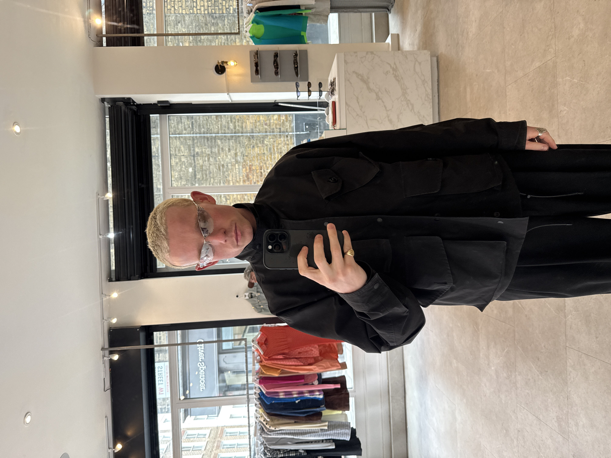 Person takes selfie in London wearing utility jacket