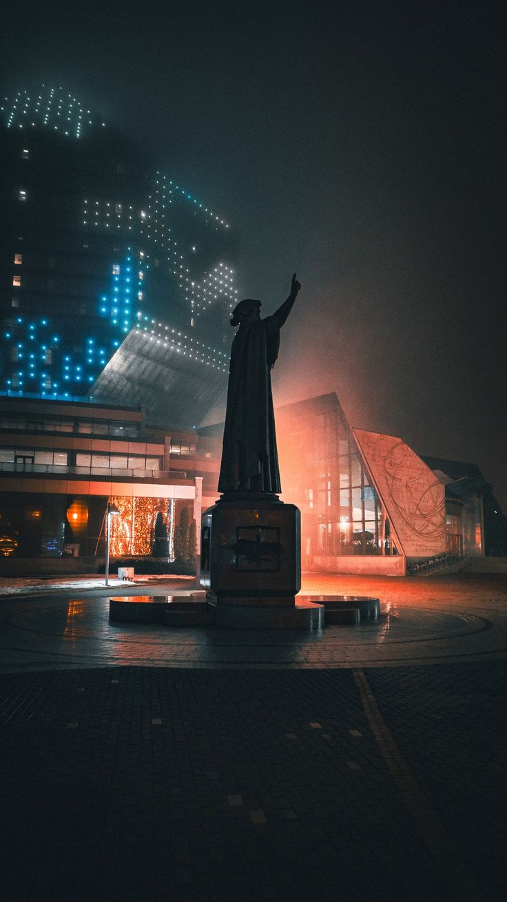 Statue with raised arm observed in Minsk square at night
