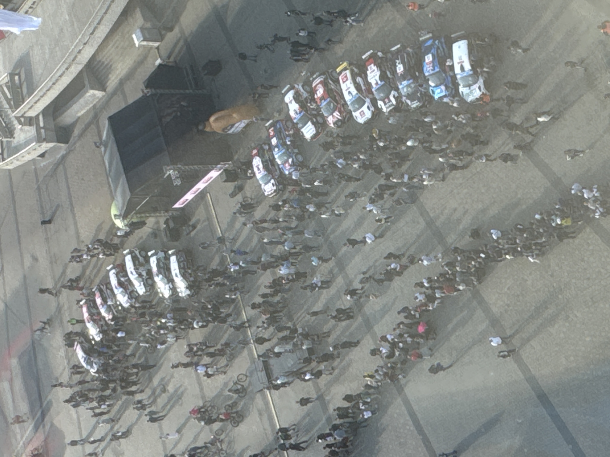 Rally cars drift and display at a sunny urban motorsport event
