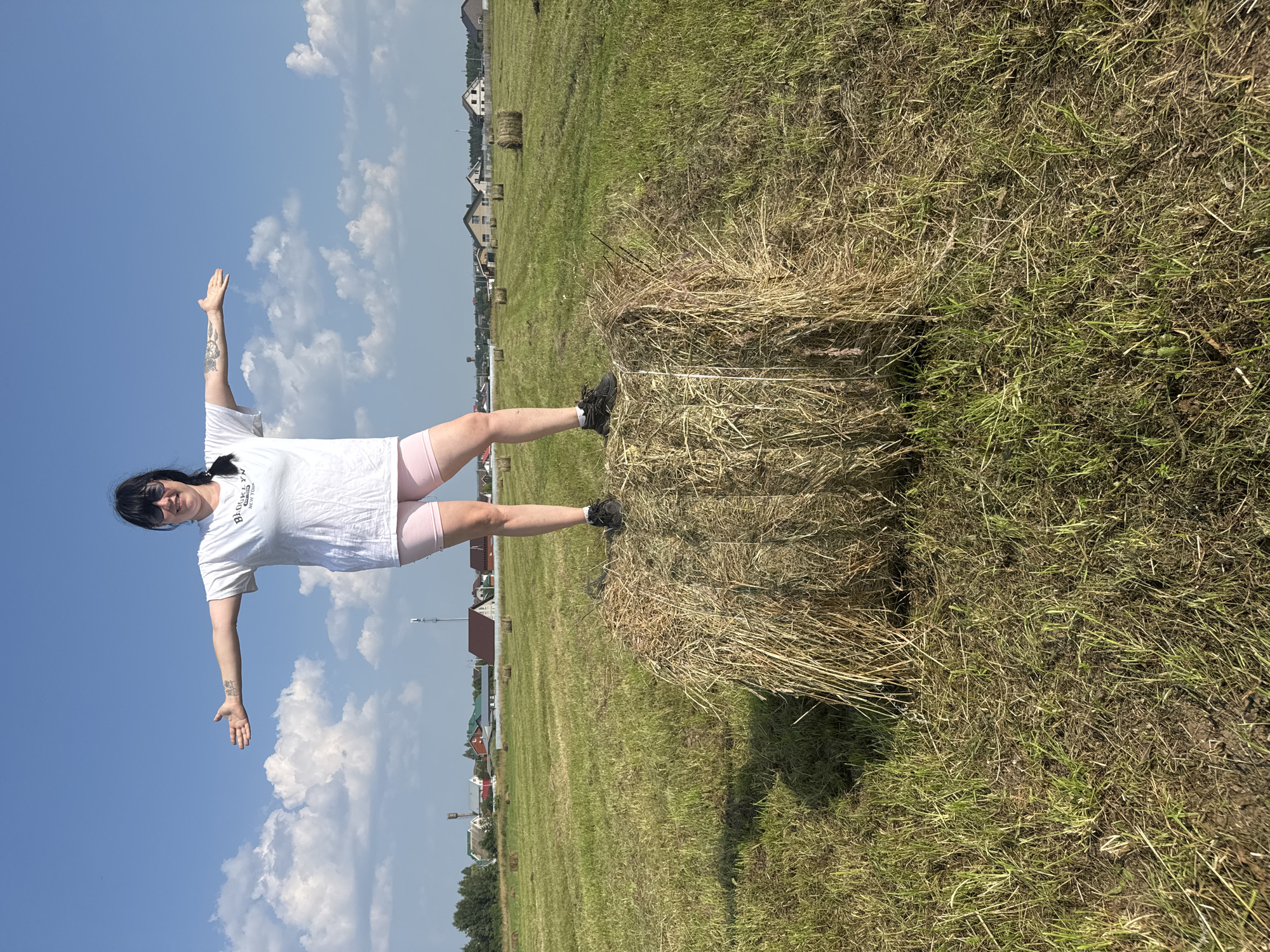 Balancing on a hay bale in a Russian summer field