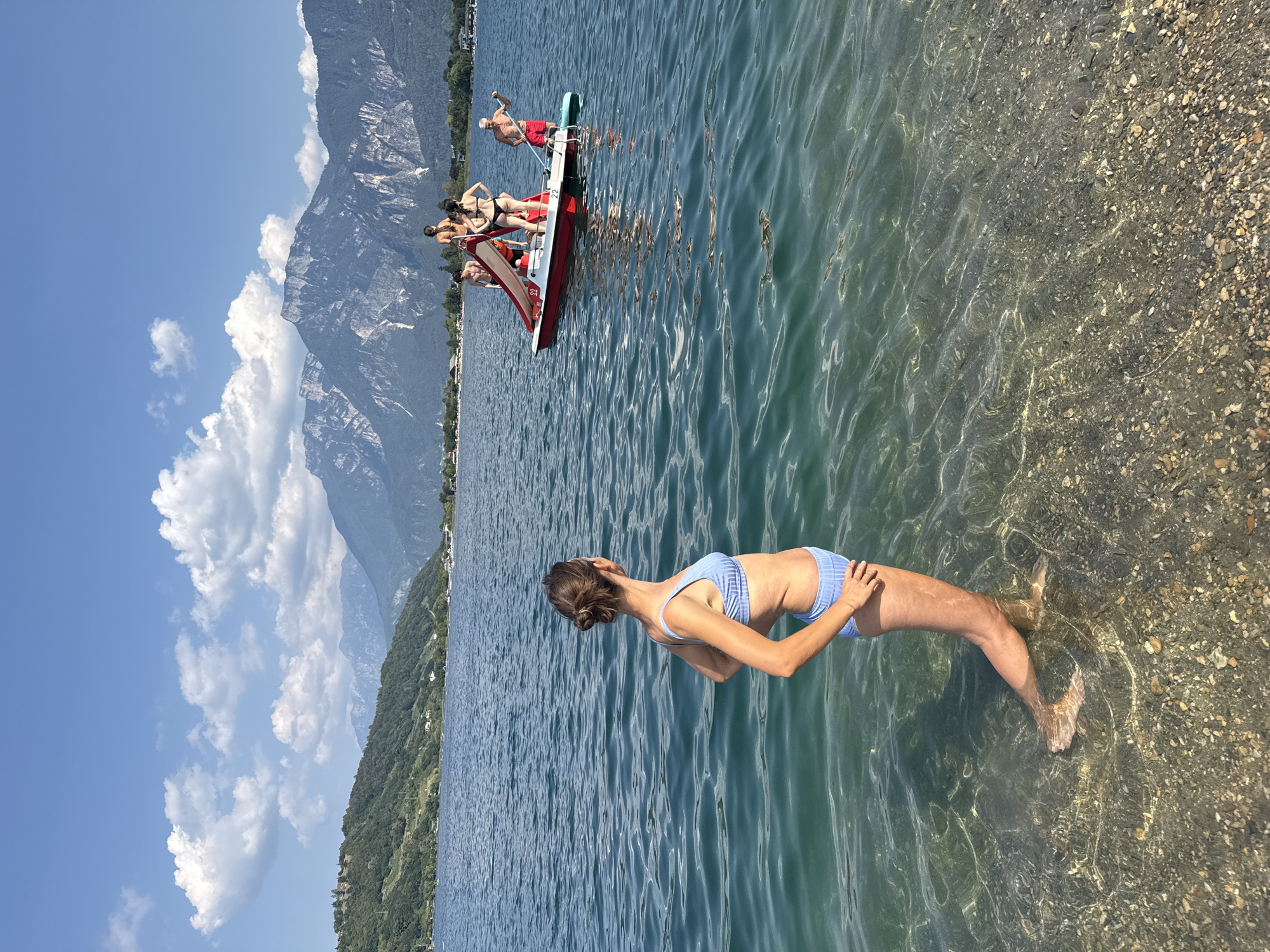 Summer afternoon on an Italian Alpine lake, boats and paddleboards out