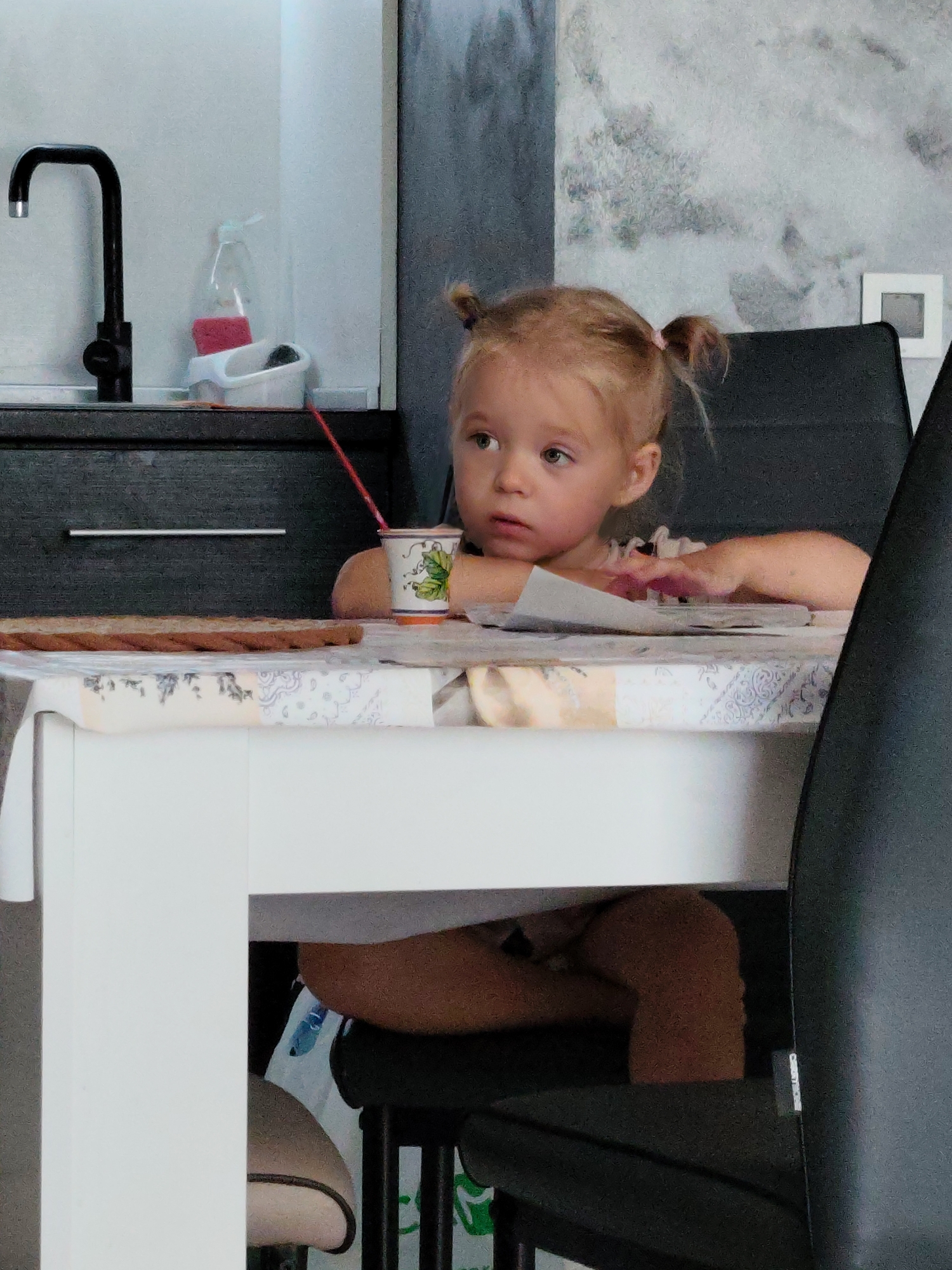 Silly face at the kitchen table, papers nearby
