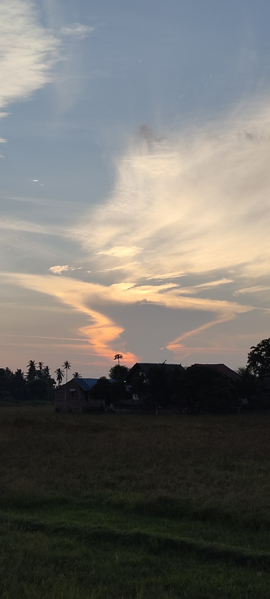 Dusk settles over rural villages and dry fields in Indonesia.