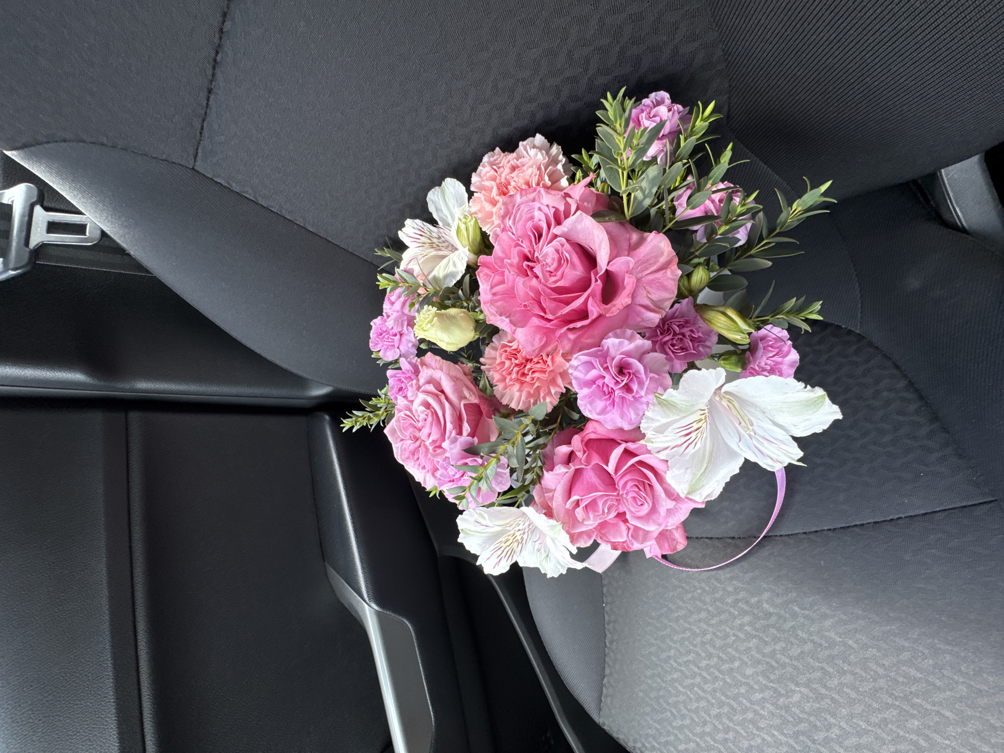 Woman photographed with flower bouquet in car, Izhevsk