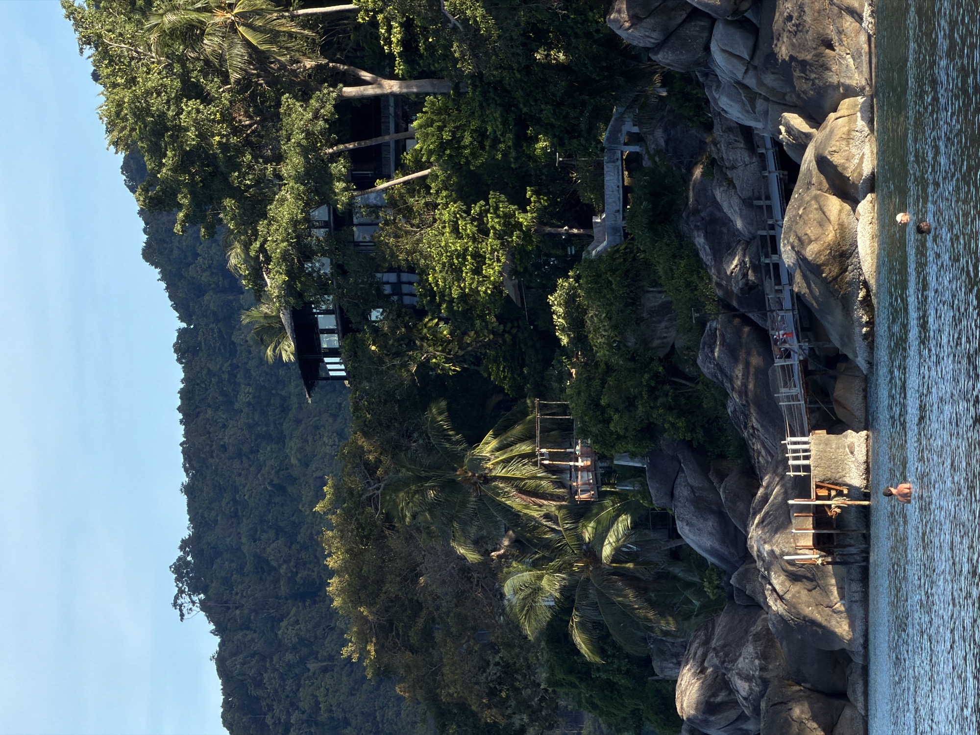 Hillside retreat and anchored sailboat along Ban Tai's coastline