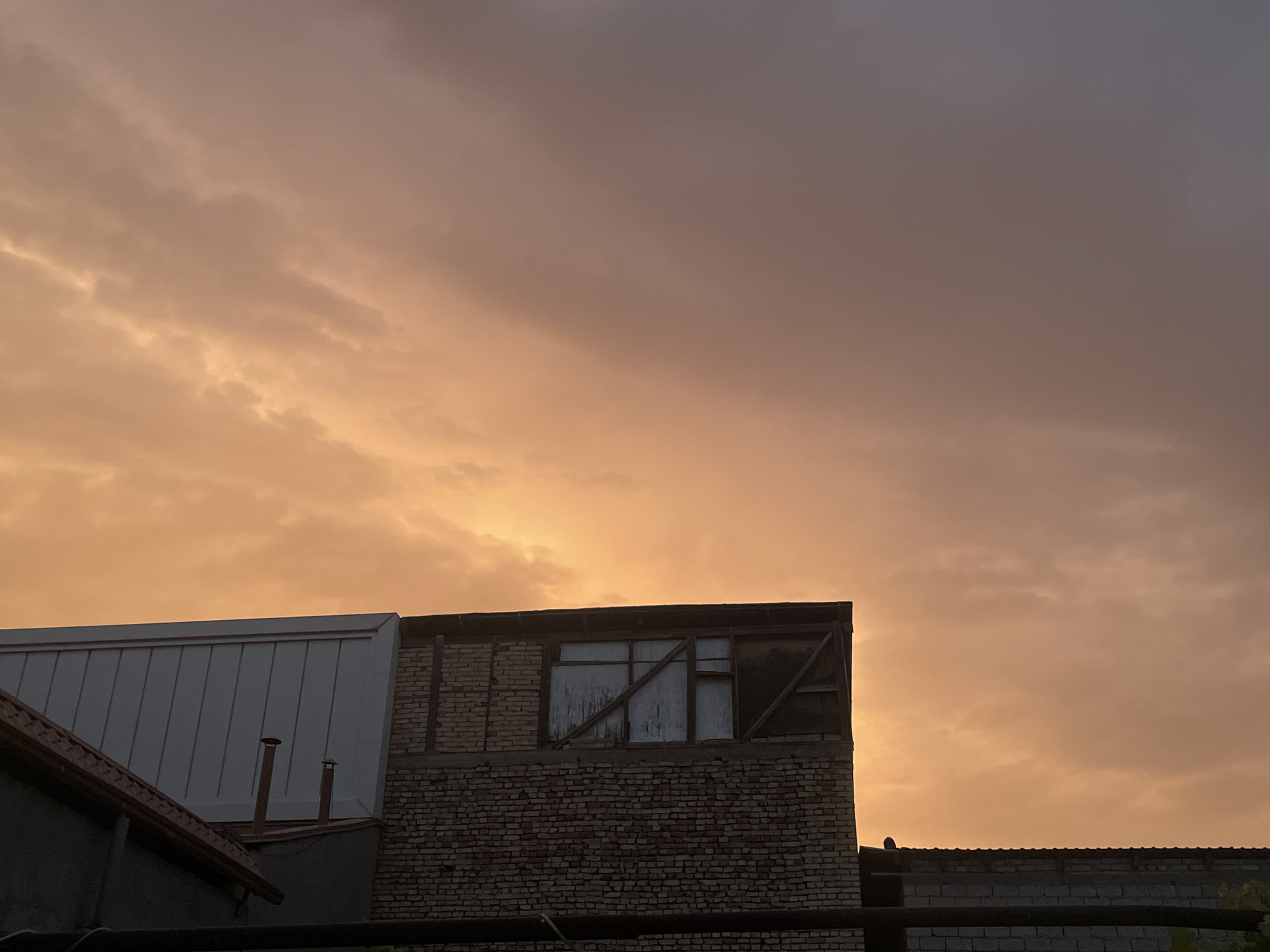 Tashkent rooftops at dusk, warm sunset colors overhead