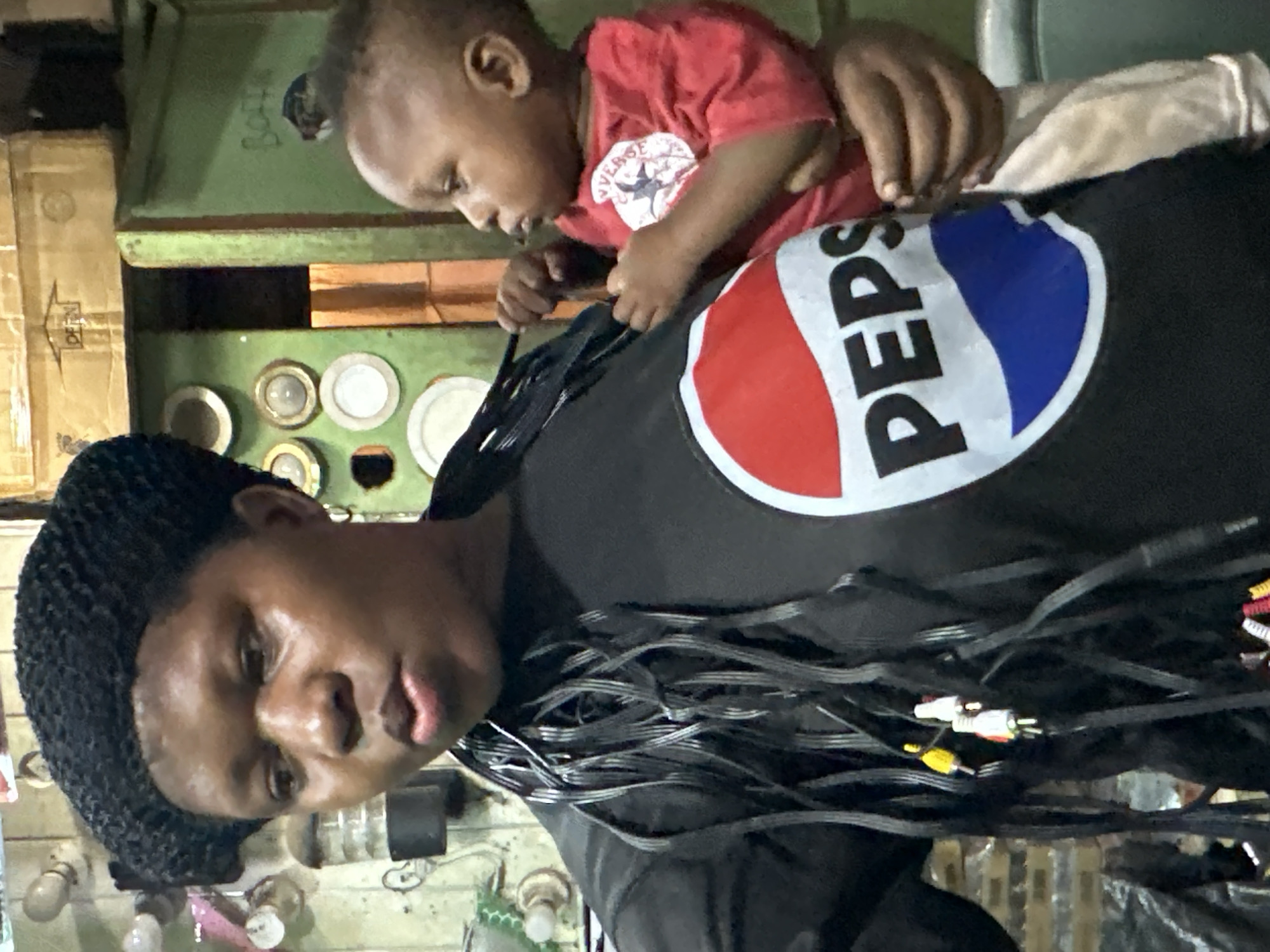 Everyday life inside a cluttered electronics shop in Narayi