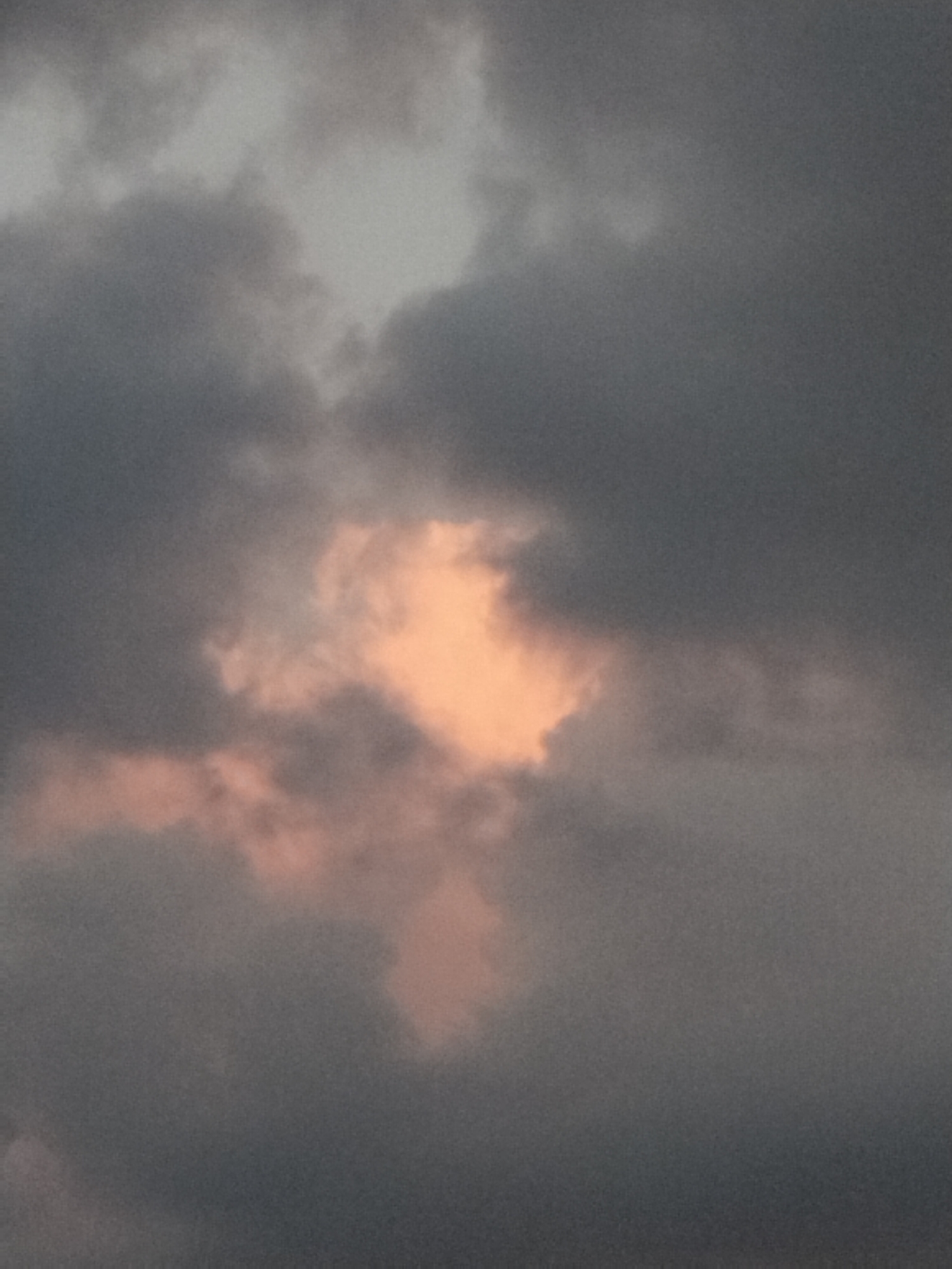 Stormy sunset sky breaking through heavy clouds