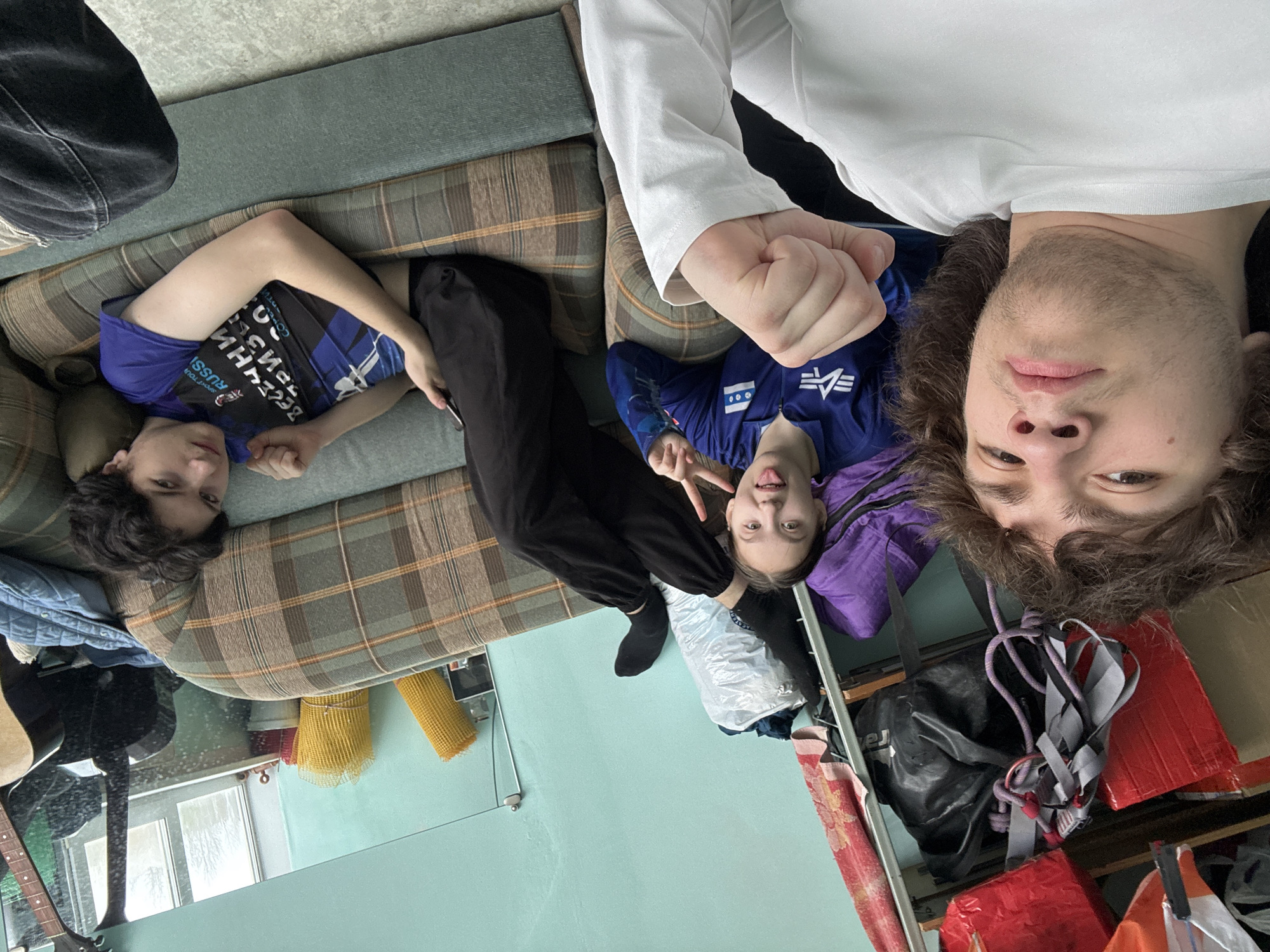 Three people photographed lying upside down on couch in Berezniki