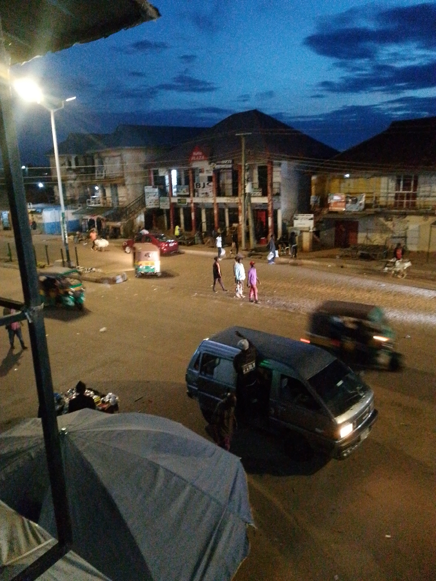 Bukuru streets at dusk, market activity and nightfall settling in