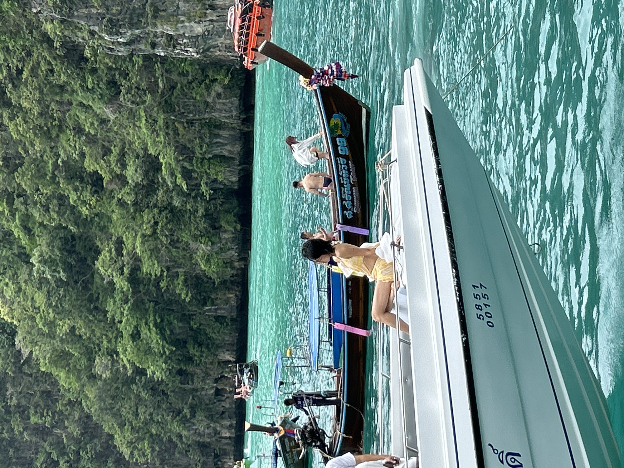 Boats and passengers navigate Ao Nang's turquoise bay