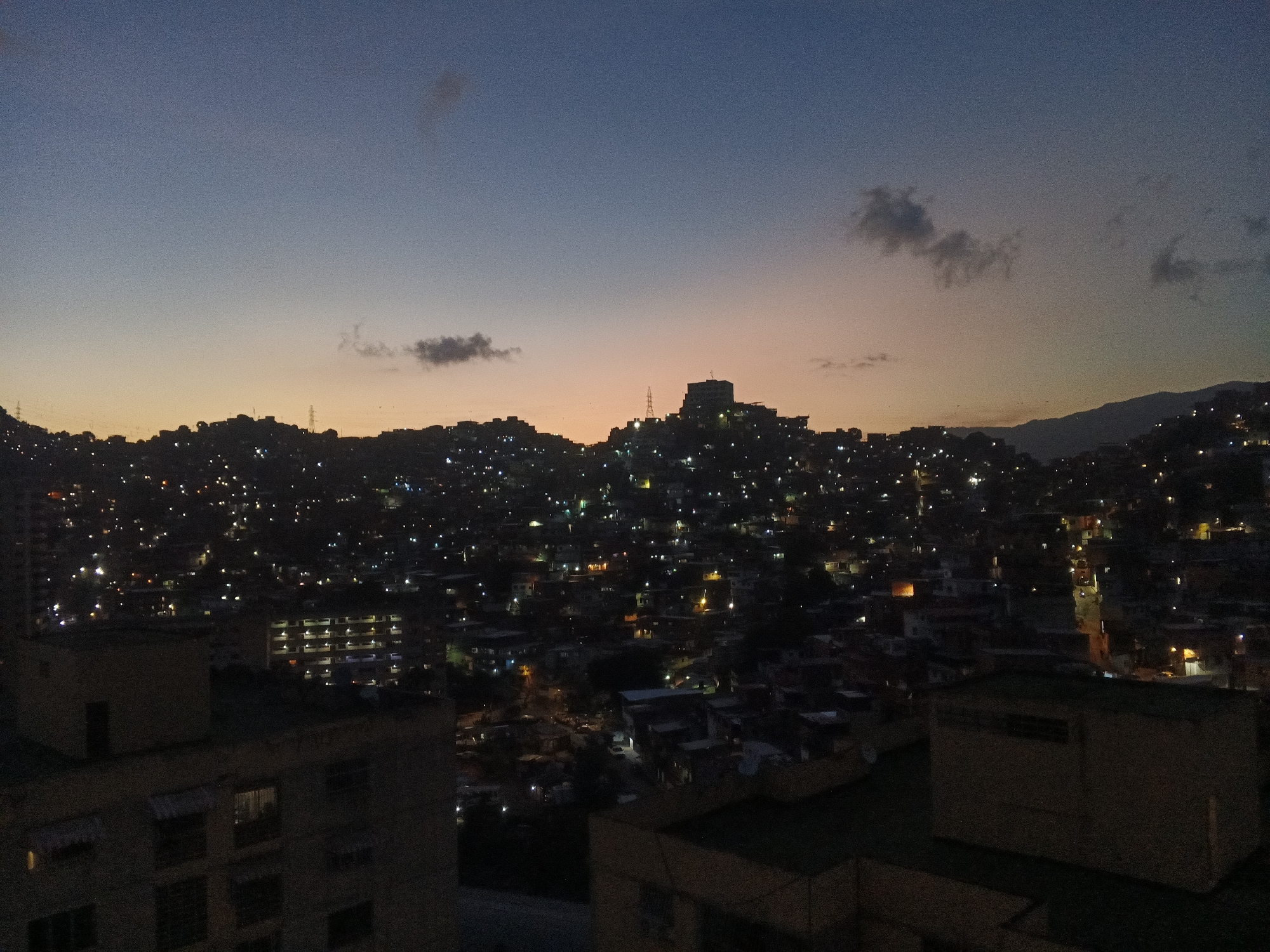 Caracas evening captured from dusk to night across hillside neighborhoods