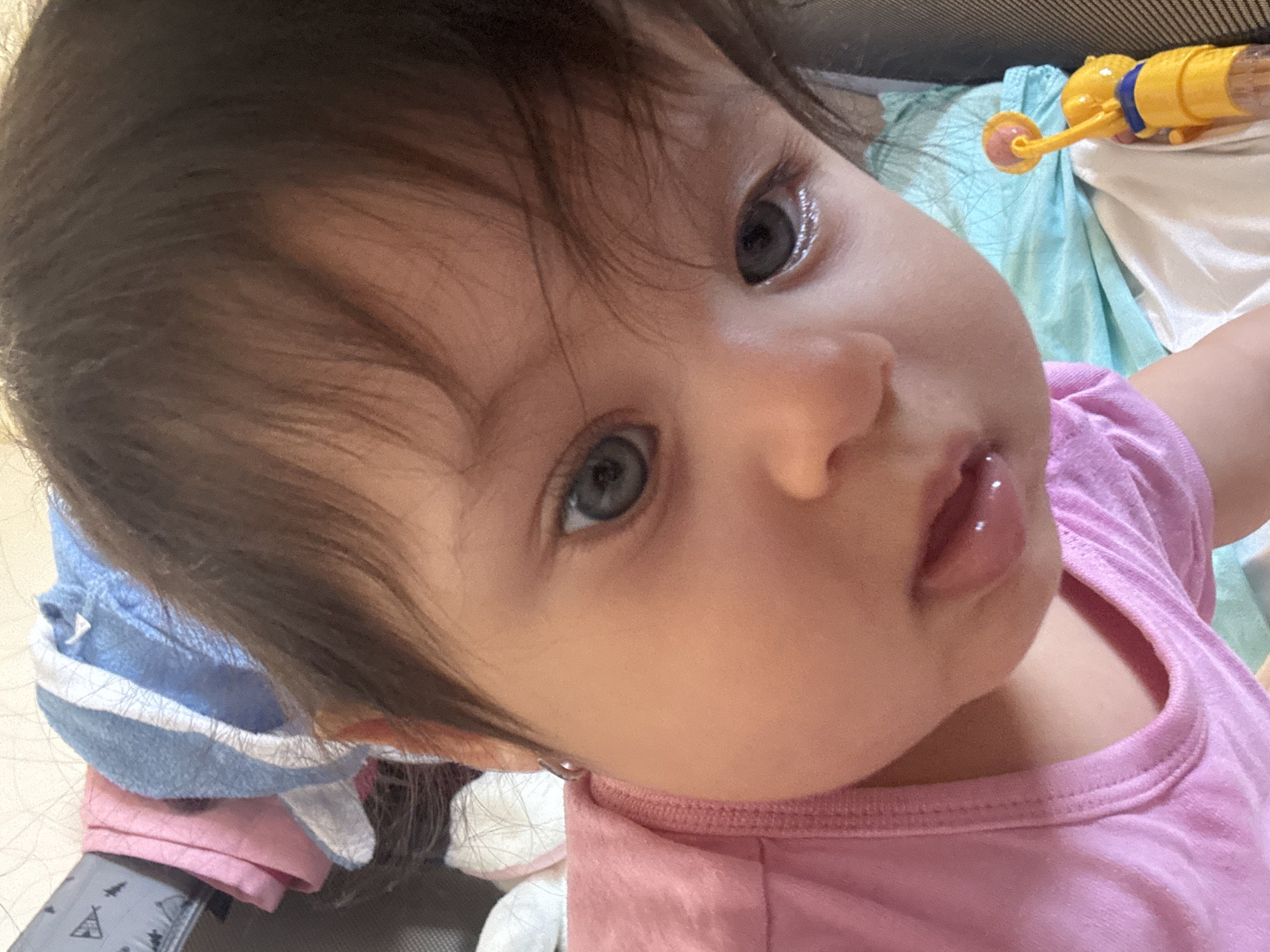 Baby girl enjoys snack time in stroller in Lincoln