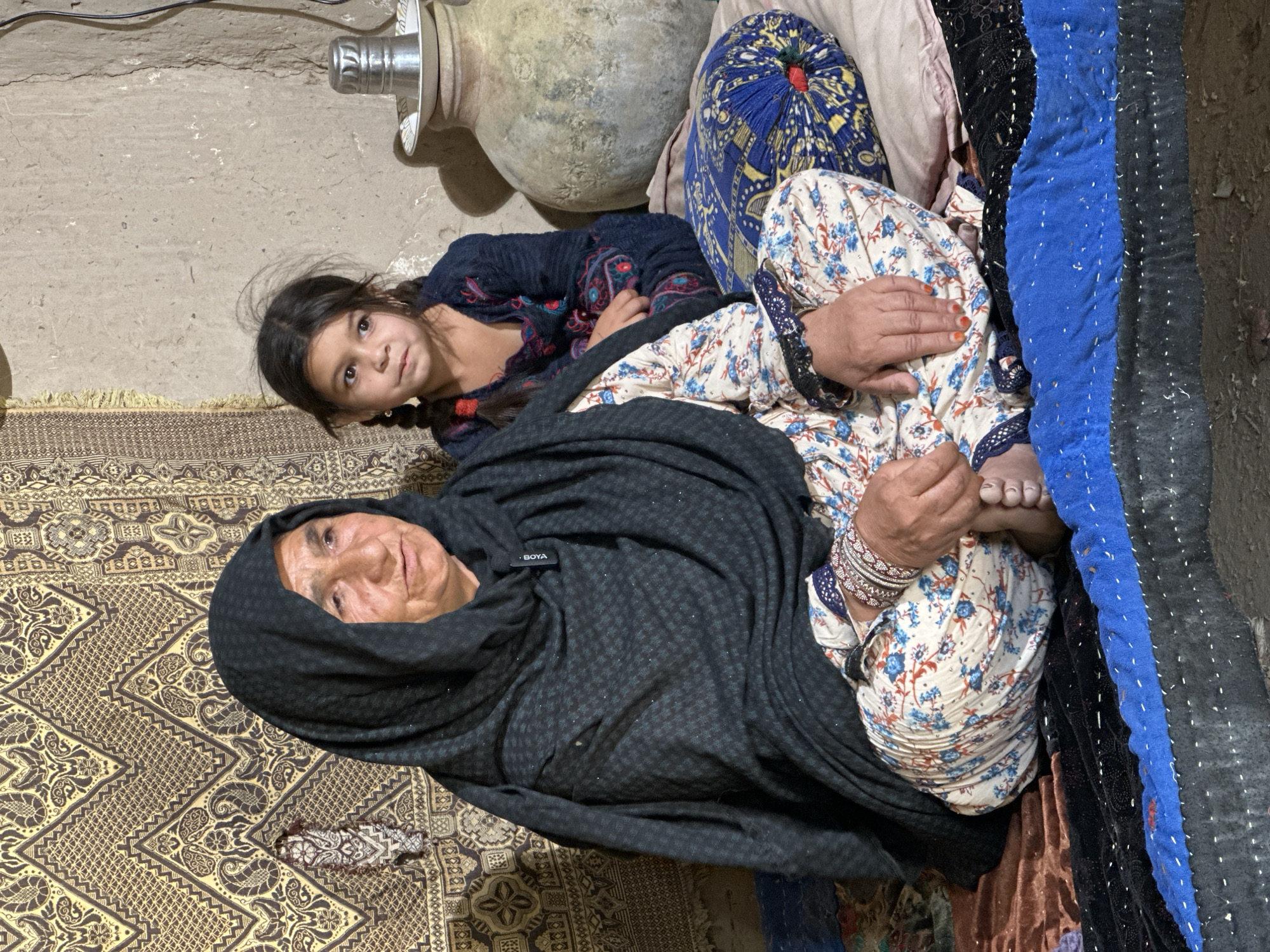Elderly woman and young girl rest together in Quetta home