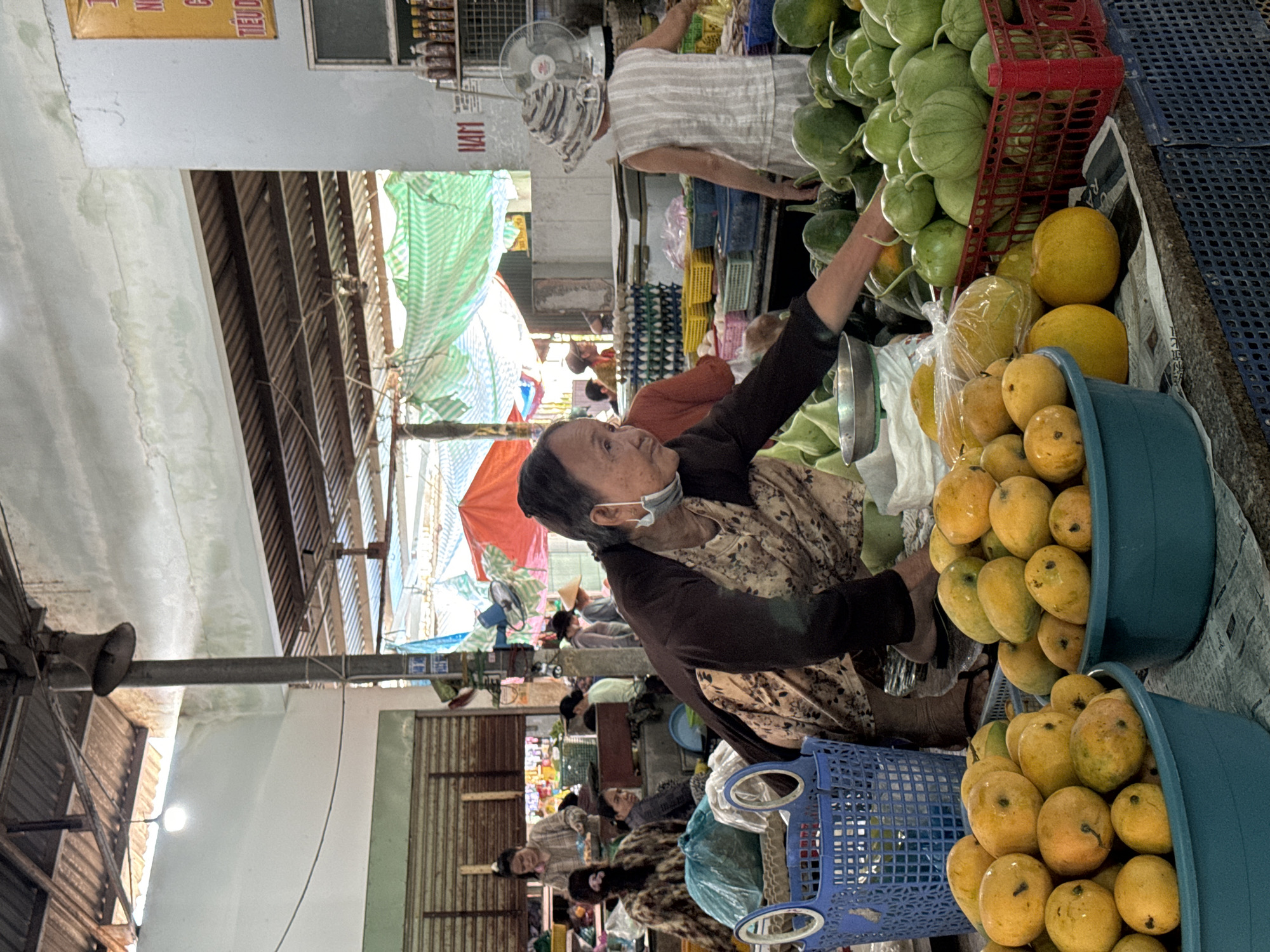 Woman shops for produce at indoor market in Mũi Né