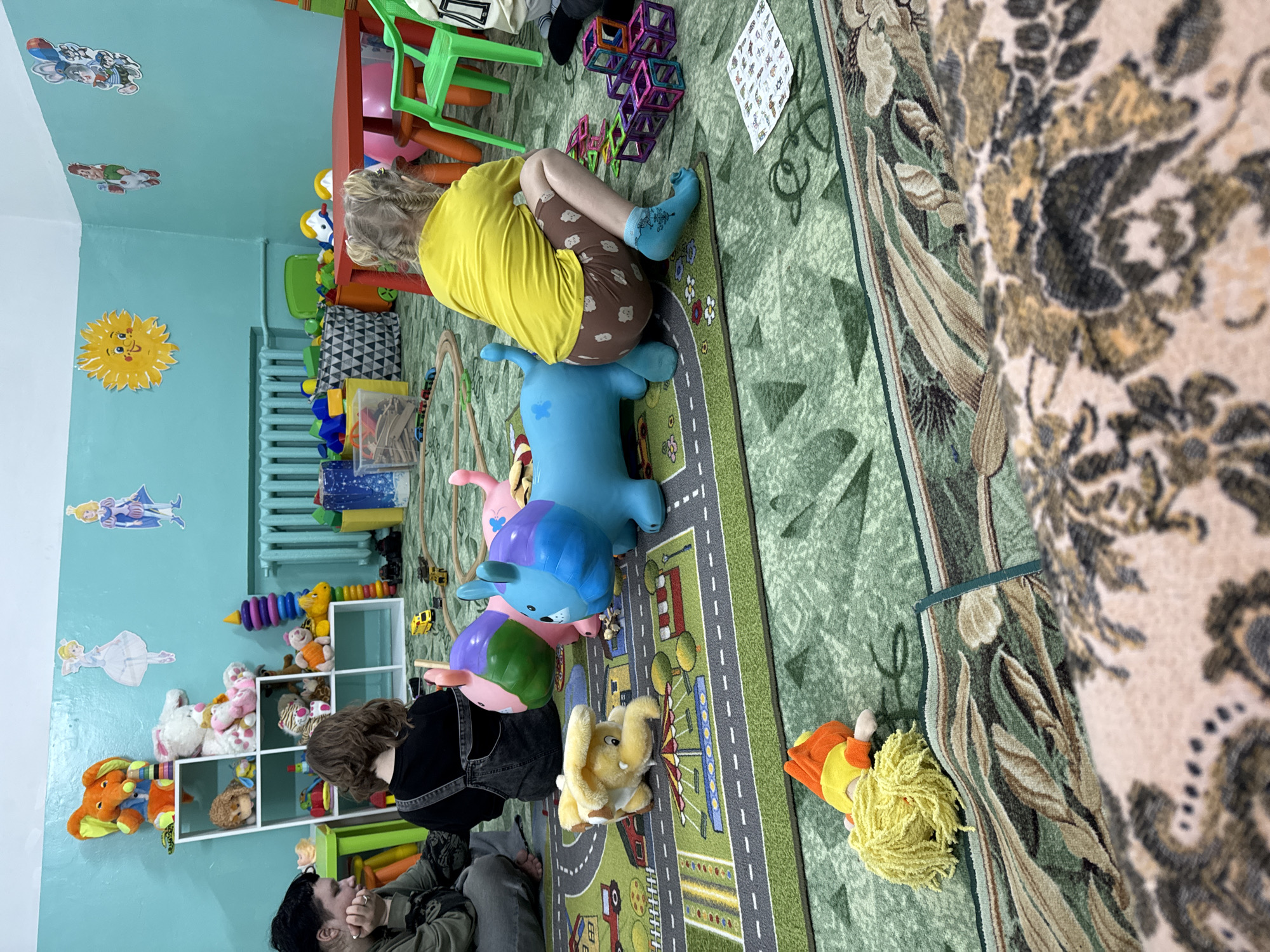 Child plays on toy animal in Anapa playroom