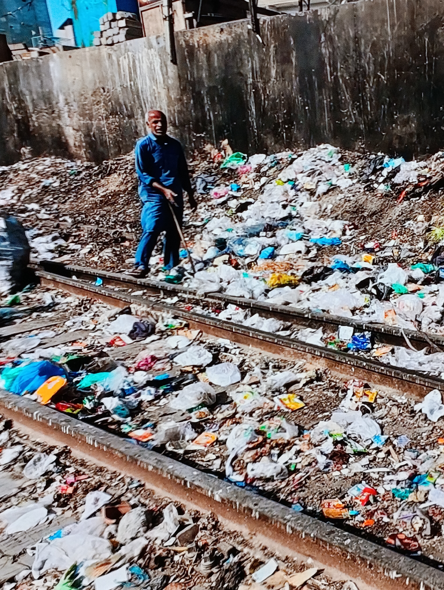 Railway tracks buried under garbage in urban area