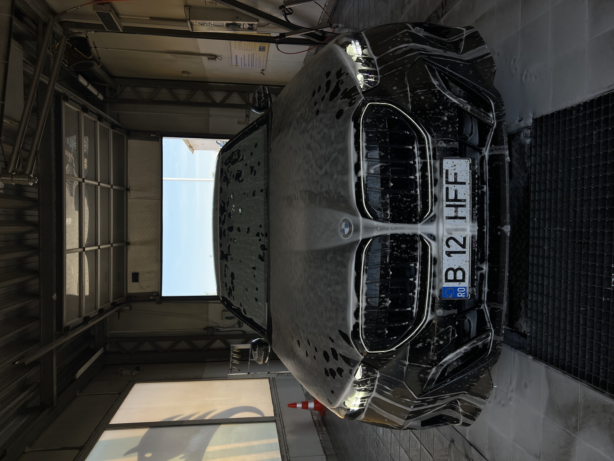 Black BMW mid-wash at a Cluj-Napoca car wash