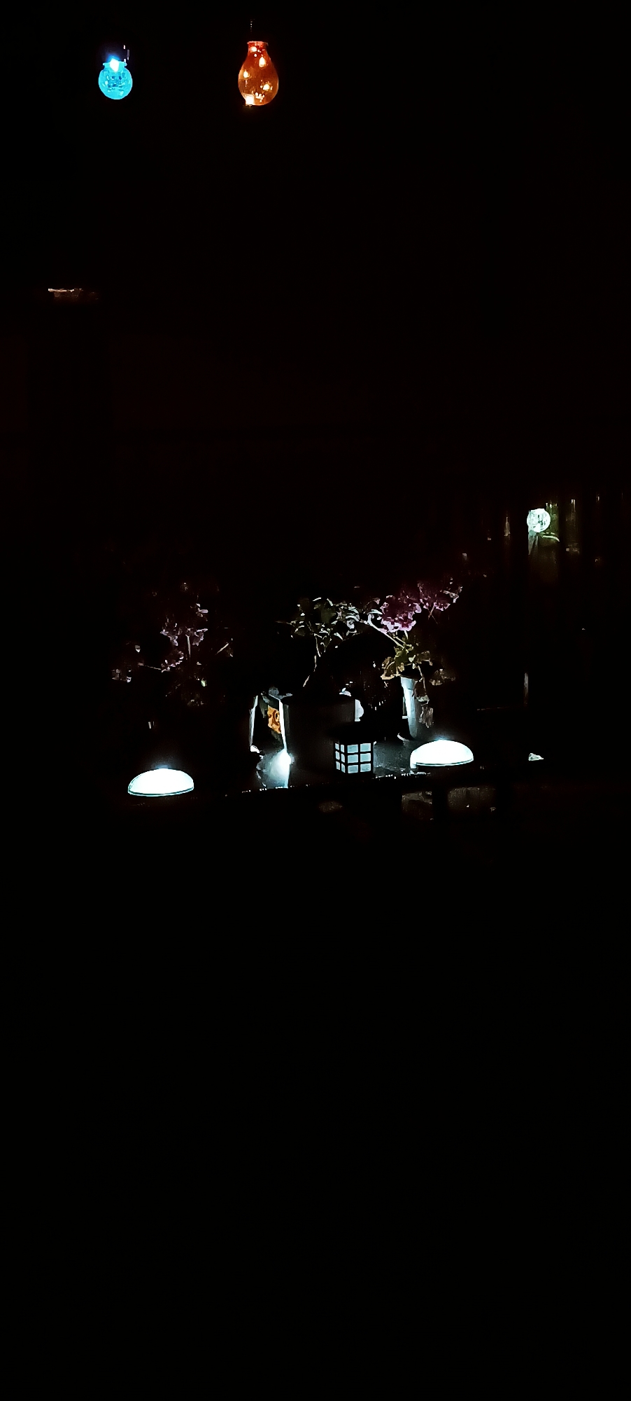 Backyard night scene with string lights and a paper lantern