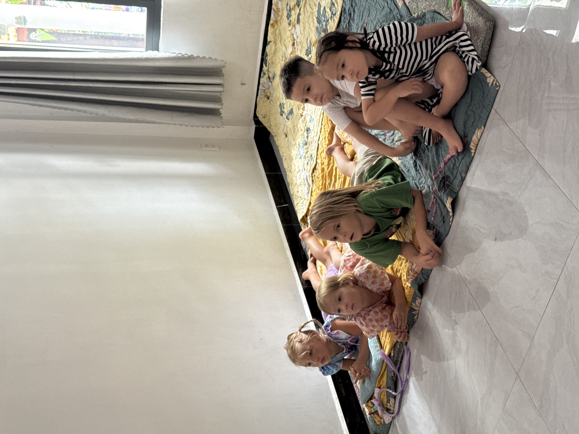 Children watch morning cartoons on living room floor in Vietnam