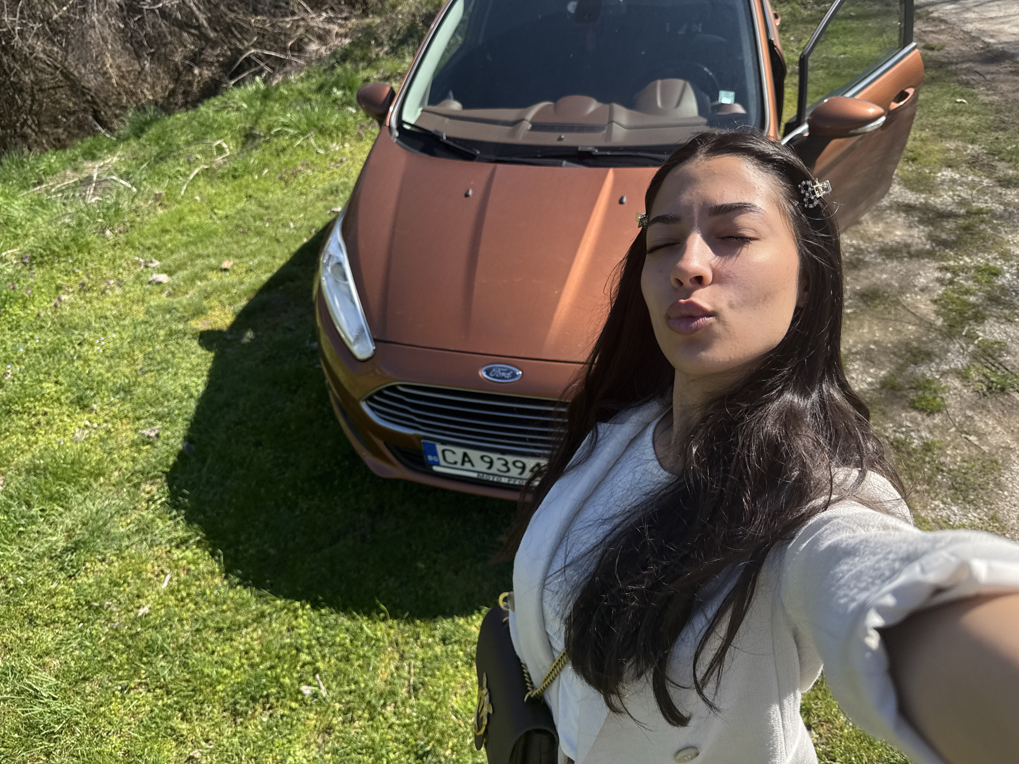 Woman takes selfie beside Ford Fiesta in Bulgarian village