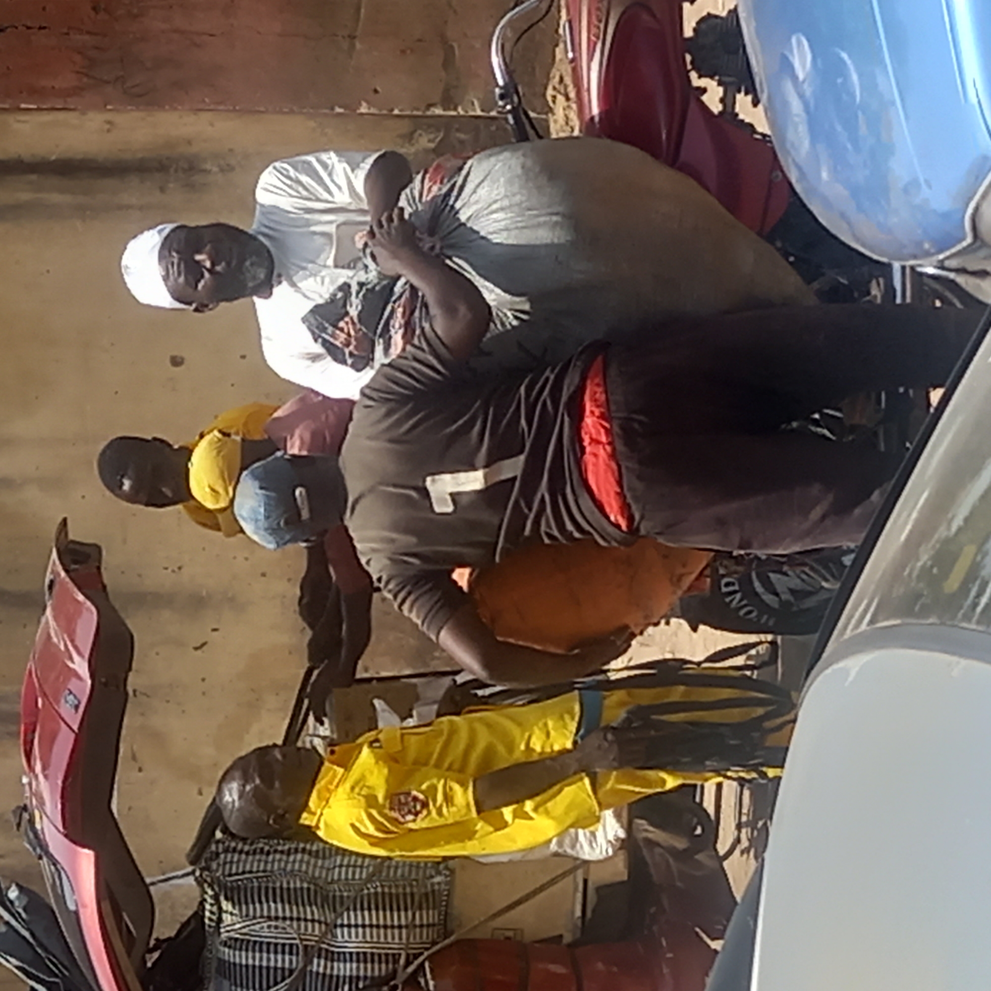 Men gather with loaded motorbikes, car in Dadi Riba