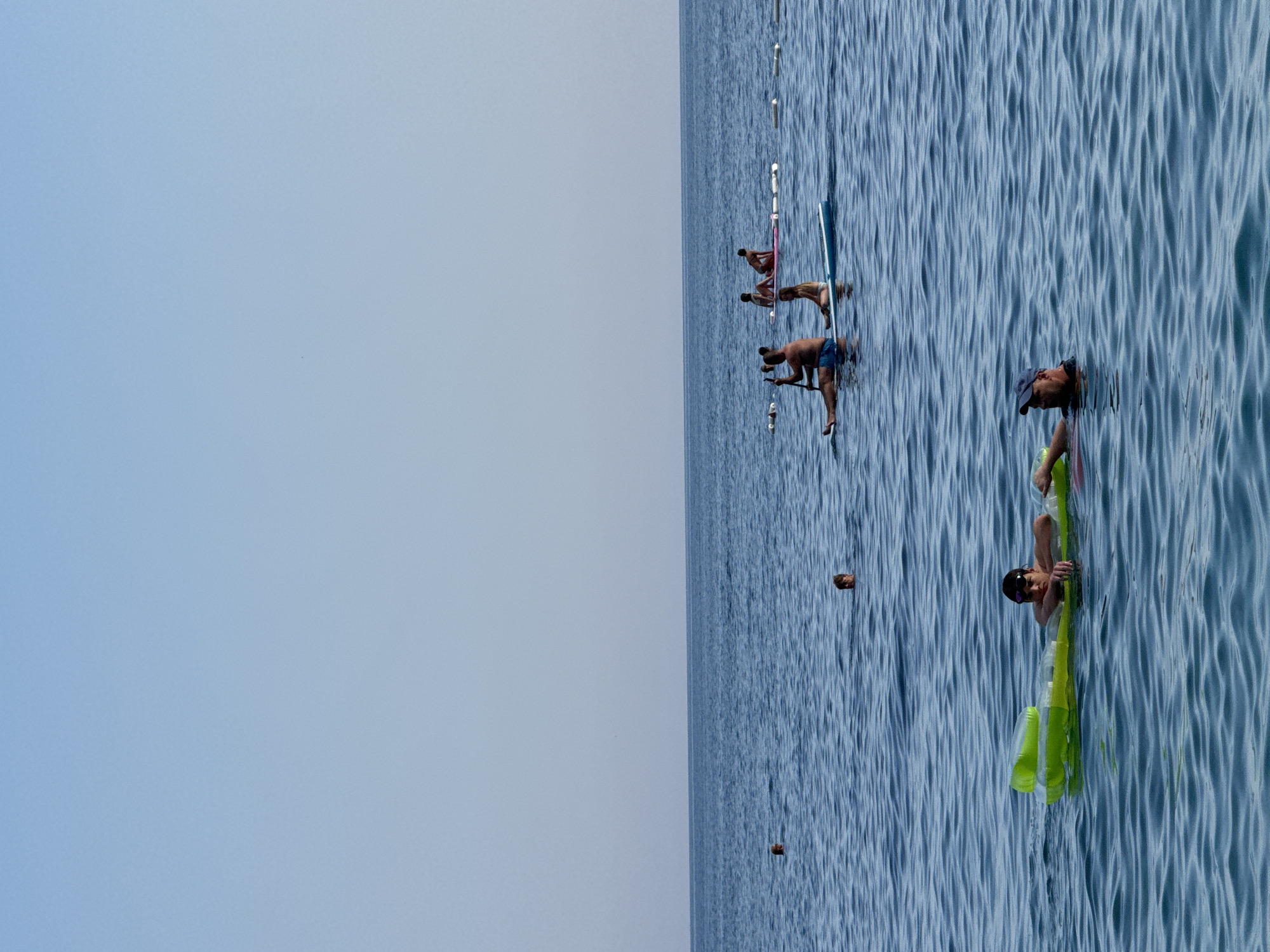 Busy summer beach day in Mirište, graffiti ruin looming behind