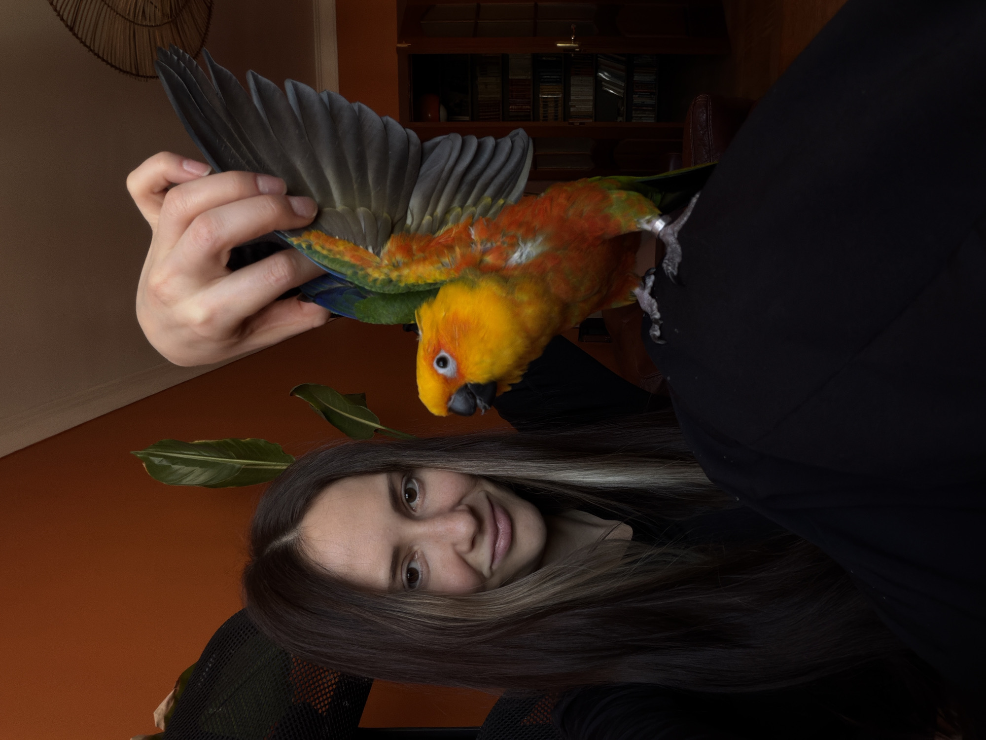 Woman bonds with Sun Conure parrot in Khimki home