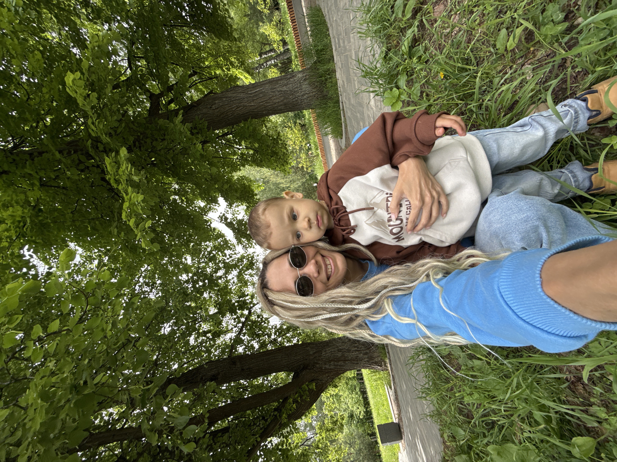 Woman and child rest in grass in Шебунино, Russia