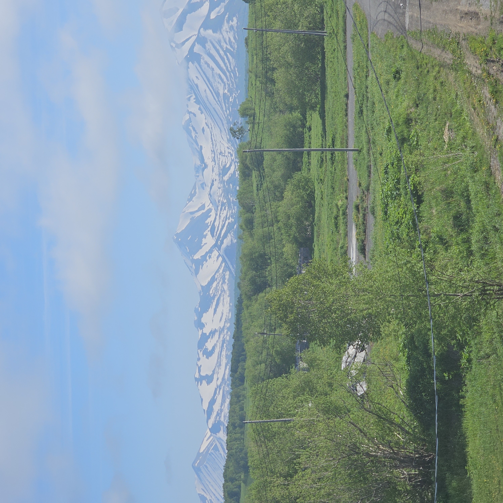 Snow-capped peaks and green fields outside Sokoch, Russia