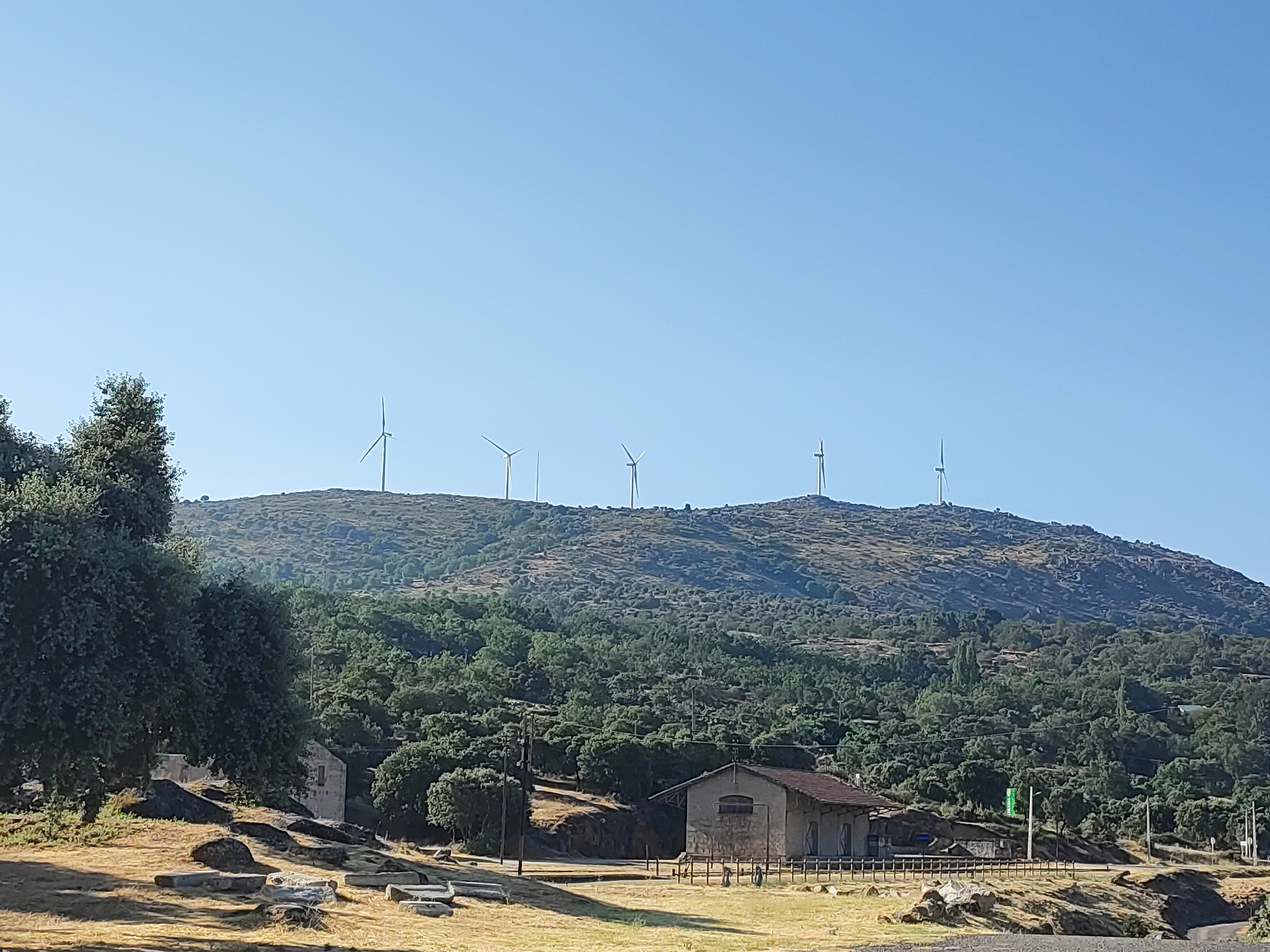 Rural viewpoint stop in Ledrada, wind turbines and oak trees