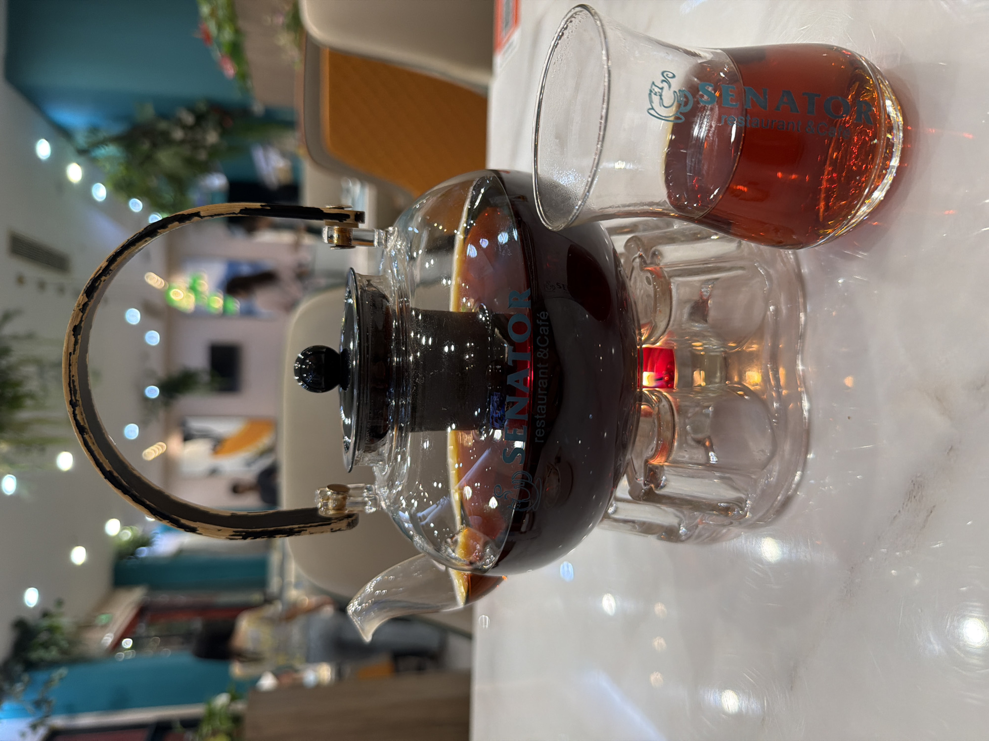 Glass teapot of tea warming over candlelight in Yiwu