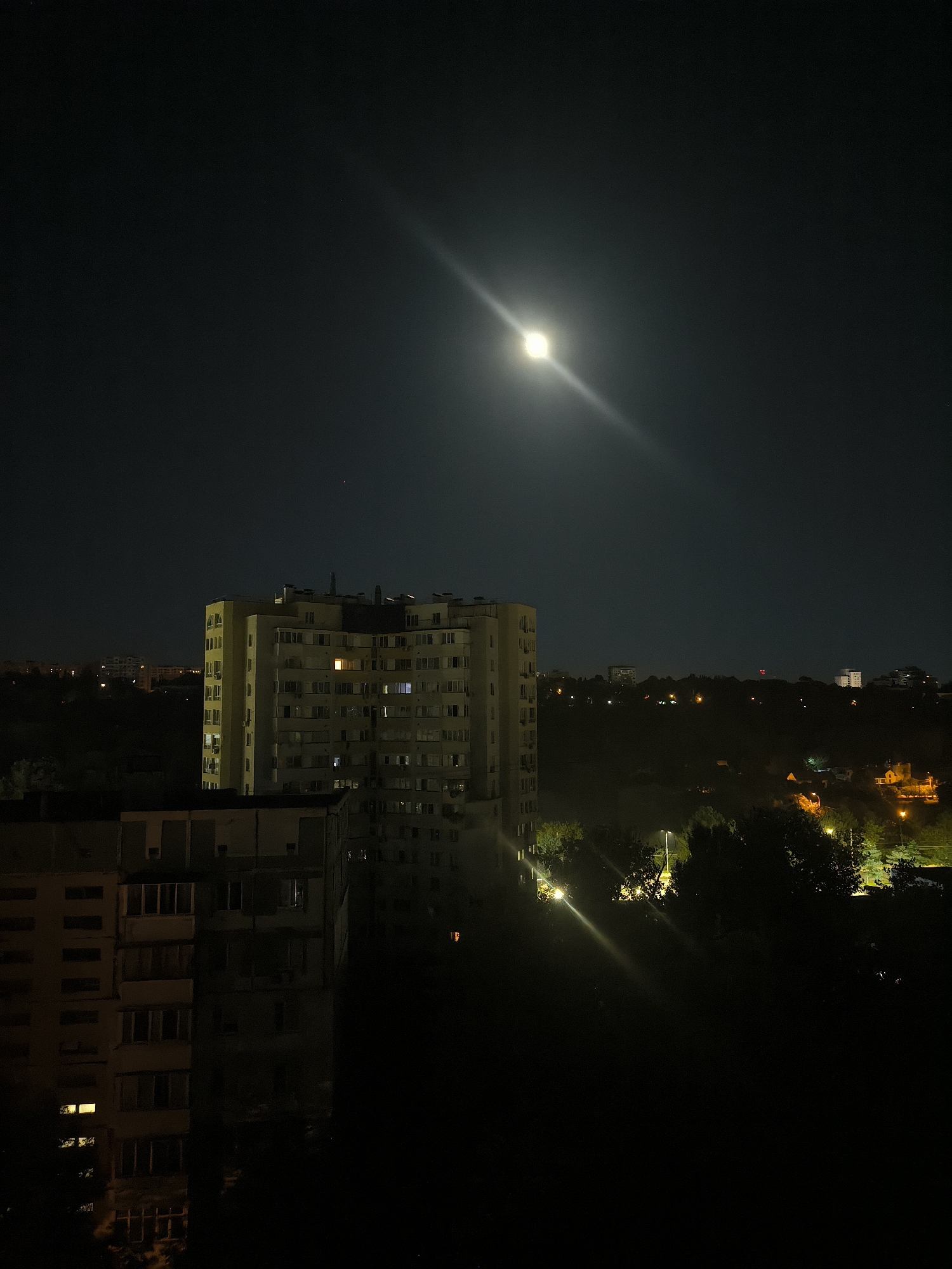 Moonlit Chișinău rooftop night, with an indoor music session