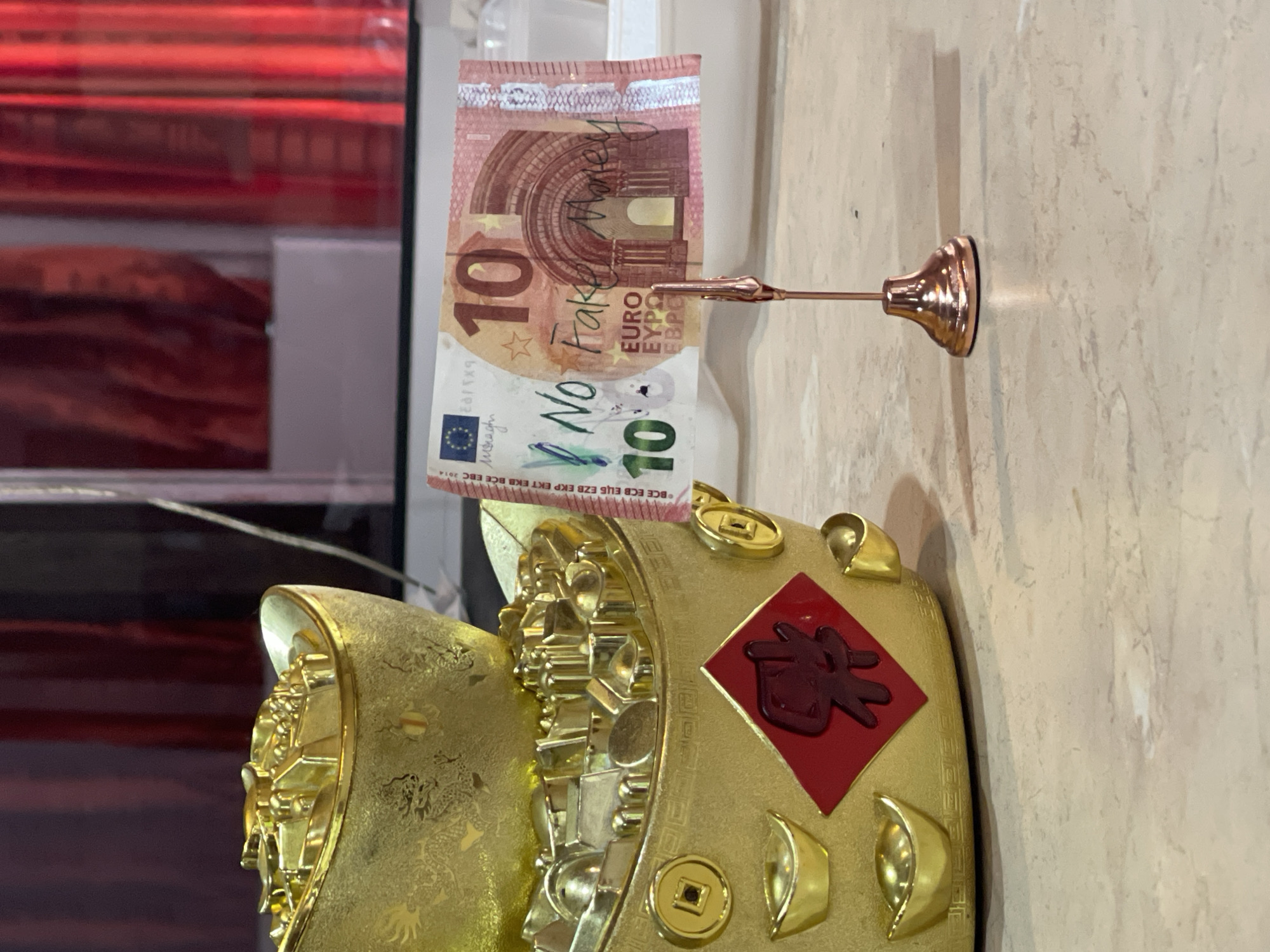 Gold Chinese figurine photographed with fake Euro note in Sofia