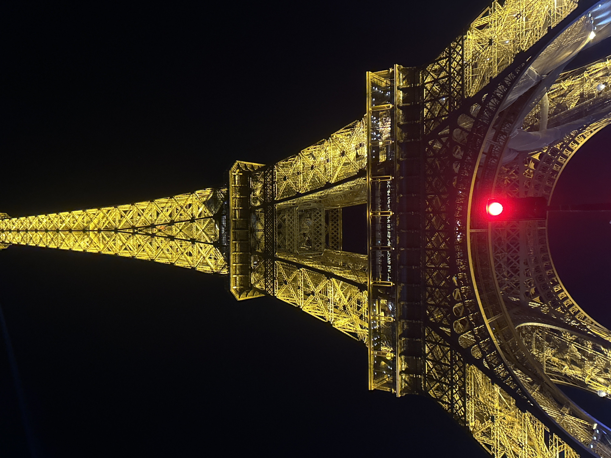 Eiffel Tower glows yellow in Paris evening darkness