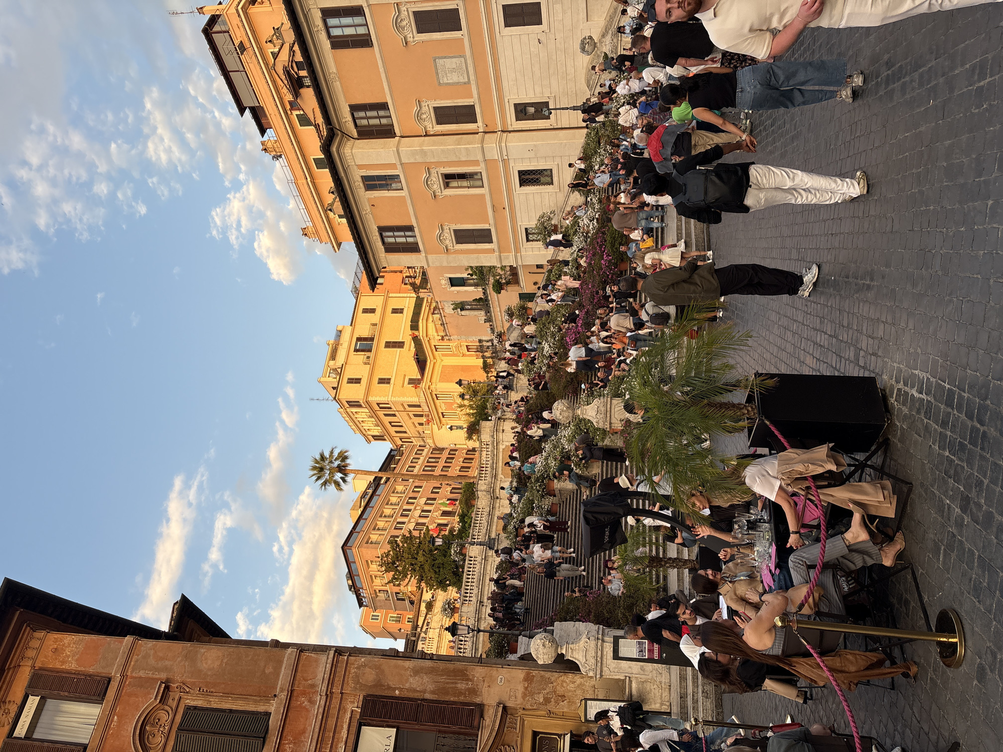 Afternoon crowds gather at Rome's Spanish Steps, street performer entertains