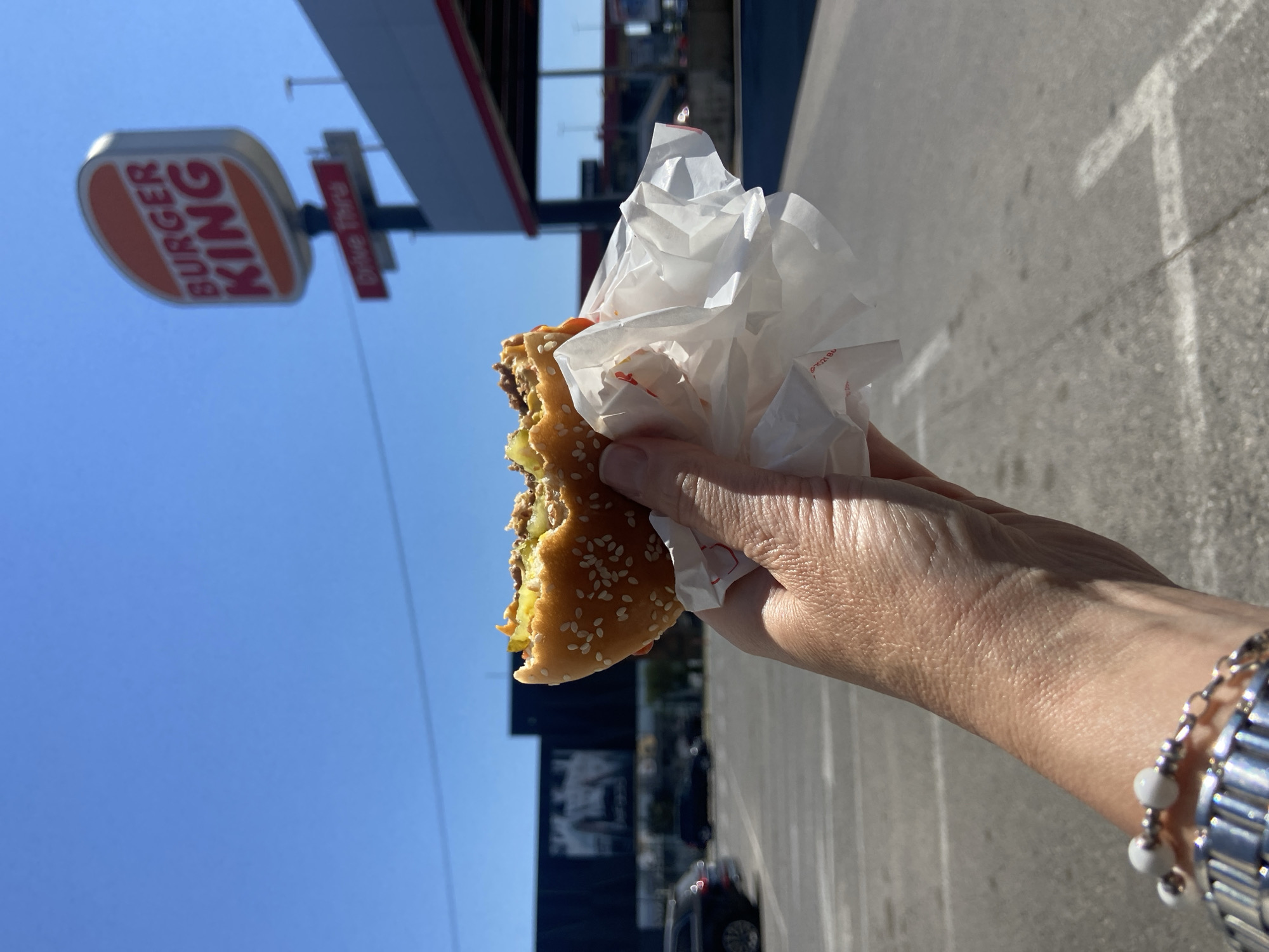 Person eats burger outside Burger King in Podgorica