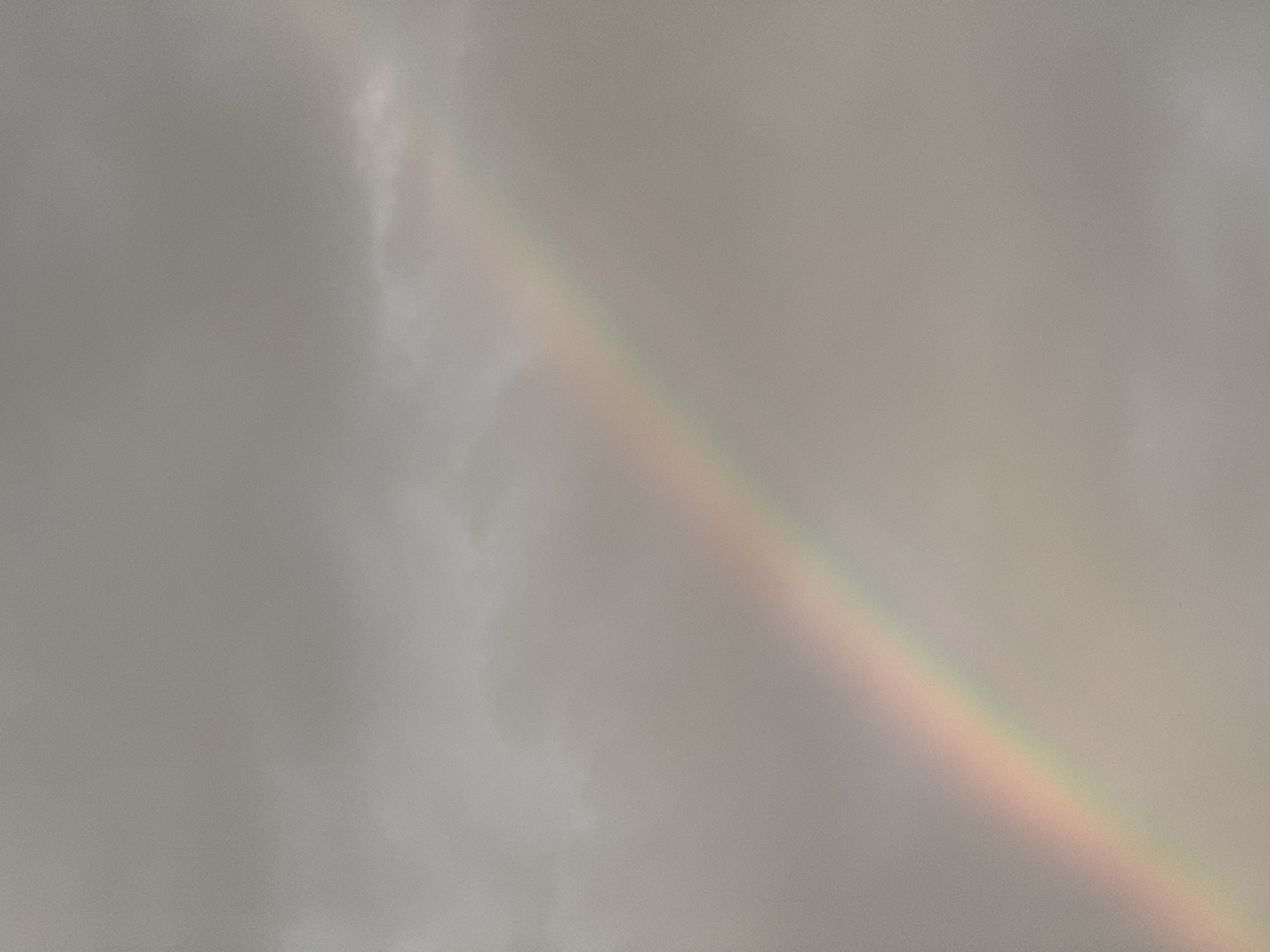 Faint rainbow over residential rooftops in Mikhaylovsk at dusk
